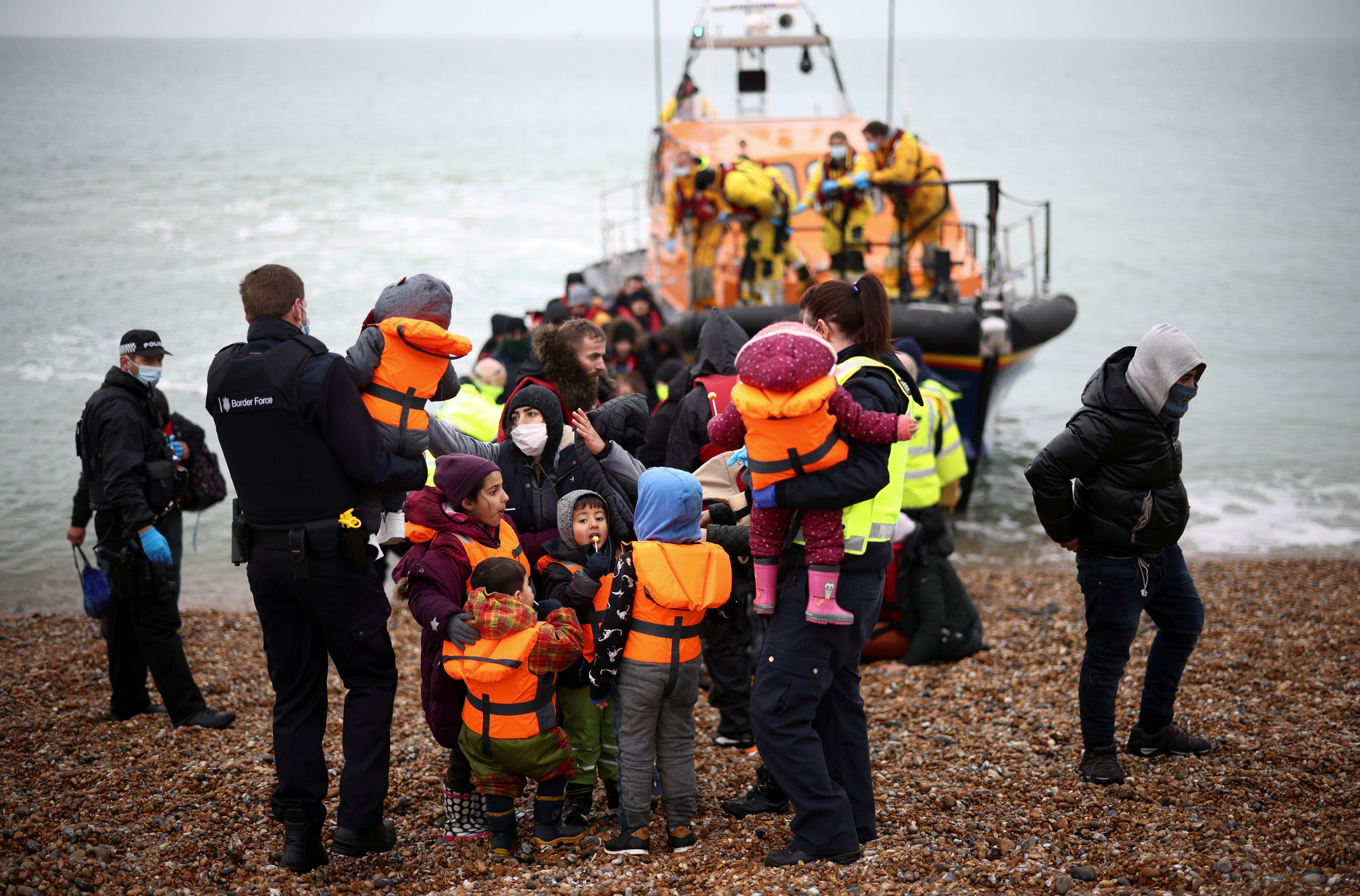 Migrants are brought ashore by the RNLI, police officers and Border Force staff, after having crossed the channel, in Dungeness