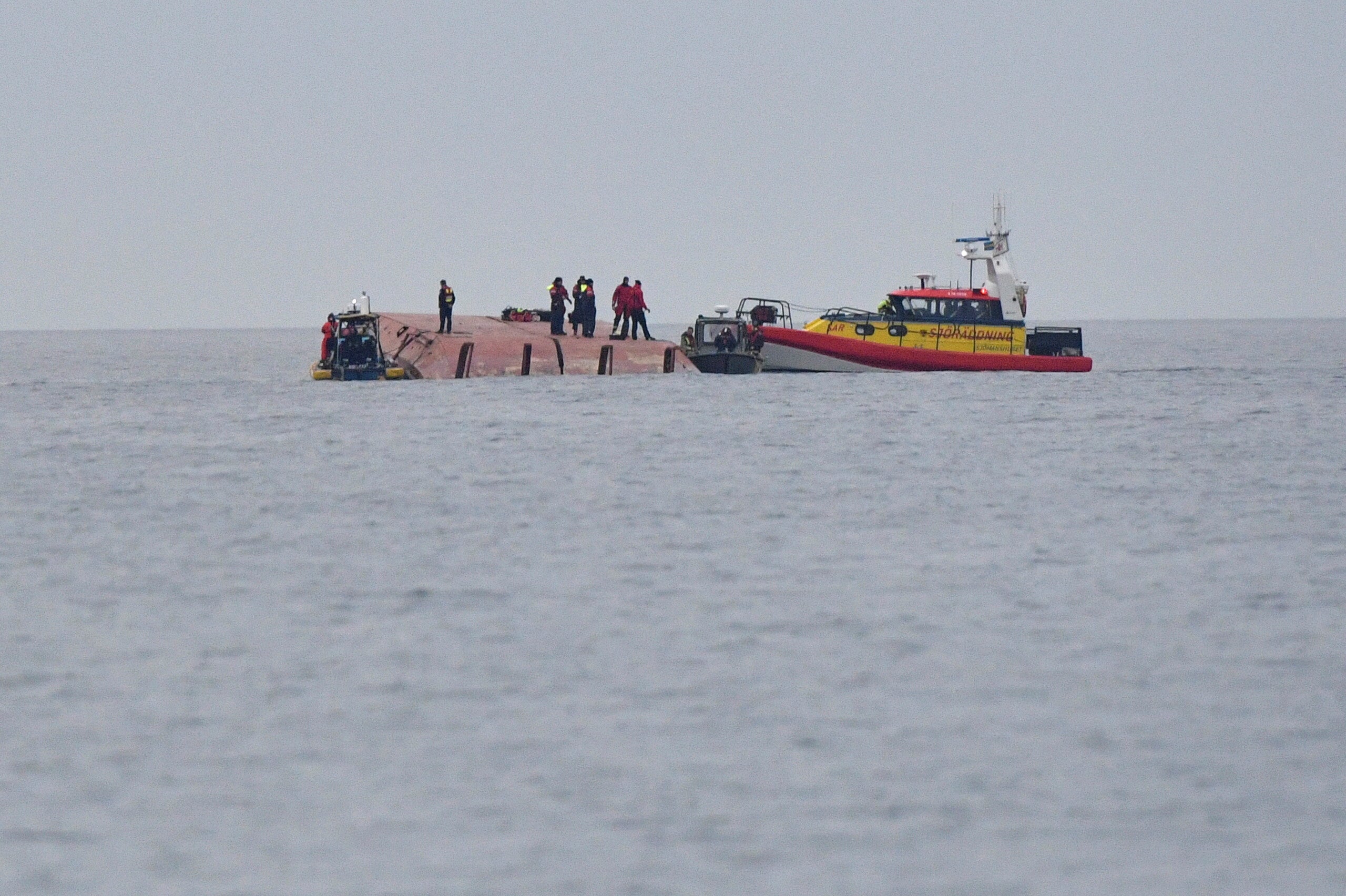 Rescue workers work aboard the Danish cargo ship Karin Hoej which collided with the British cargo ship Scot Carrier