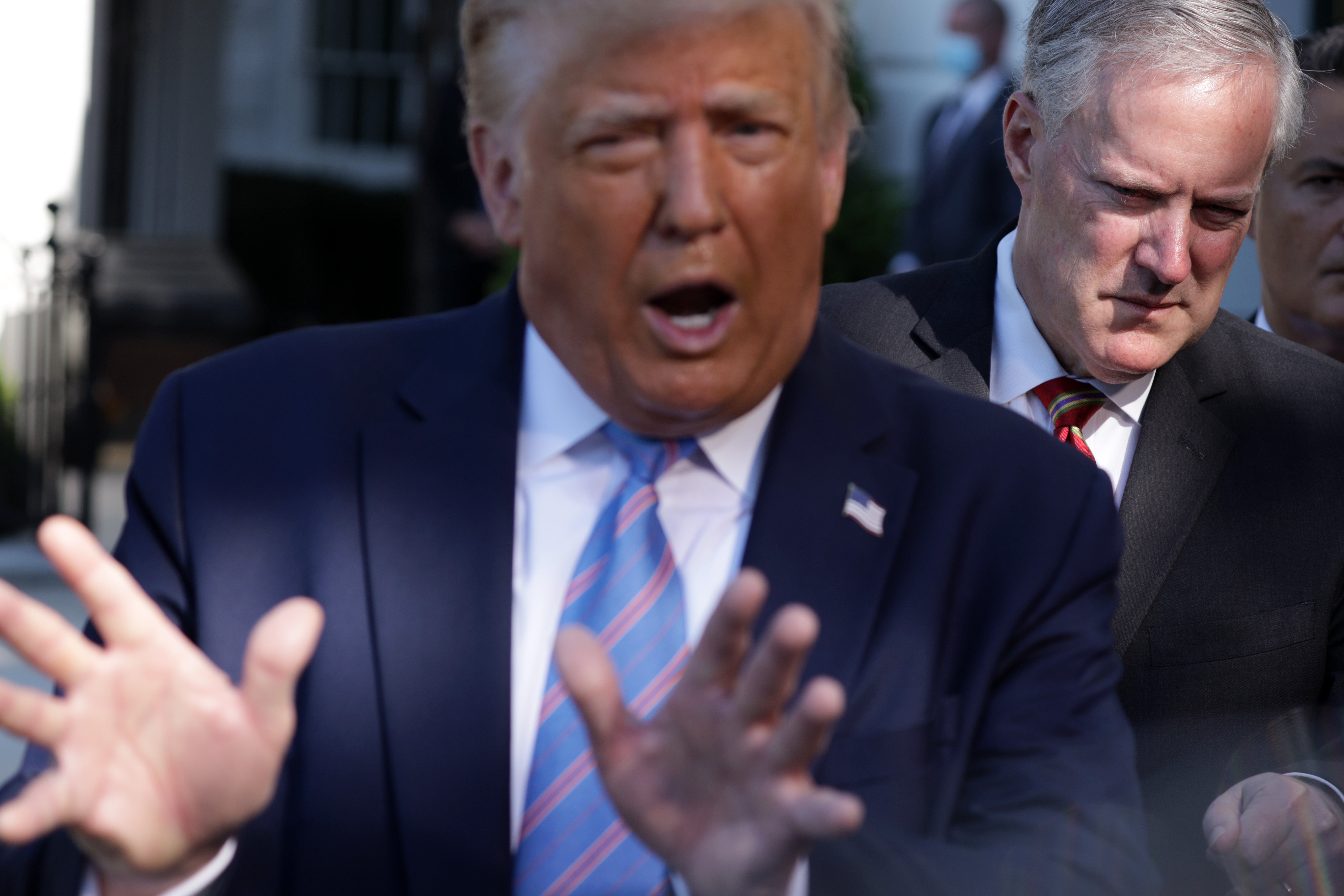 Mark Meadows stands behind Donald Trump on the South Lawn of the White House on 29 July 2020