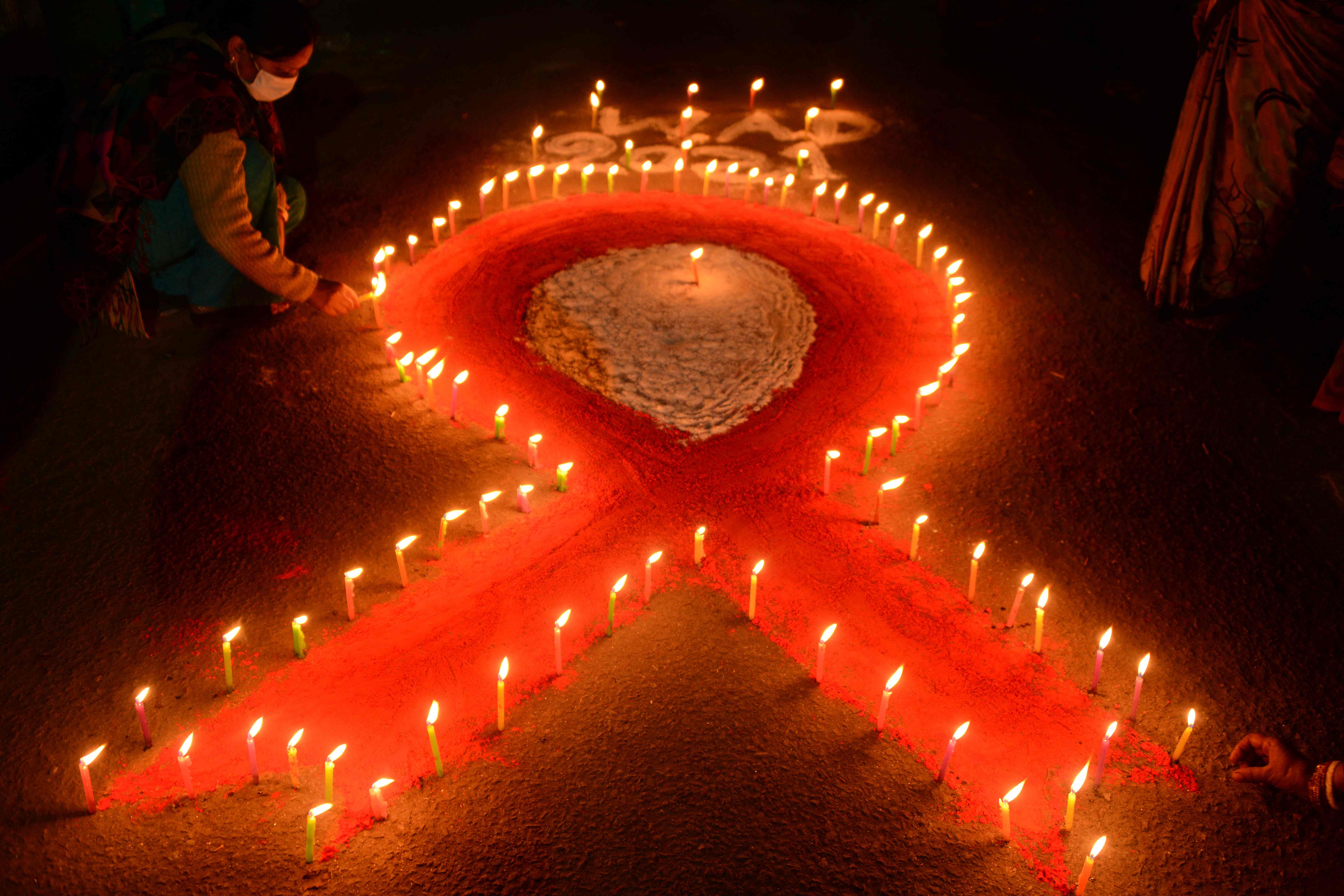 A volunteer lights candles forming the shape of a red ribbon during an awareness event organised on the eve of the World Aids Day last month