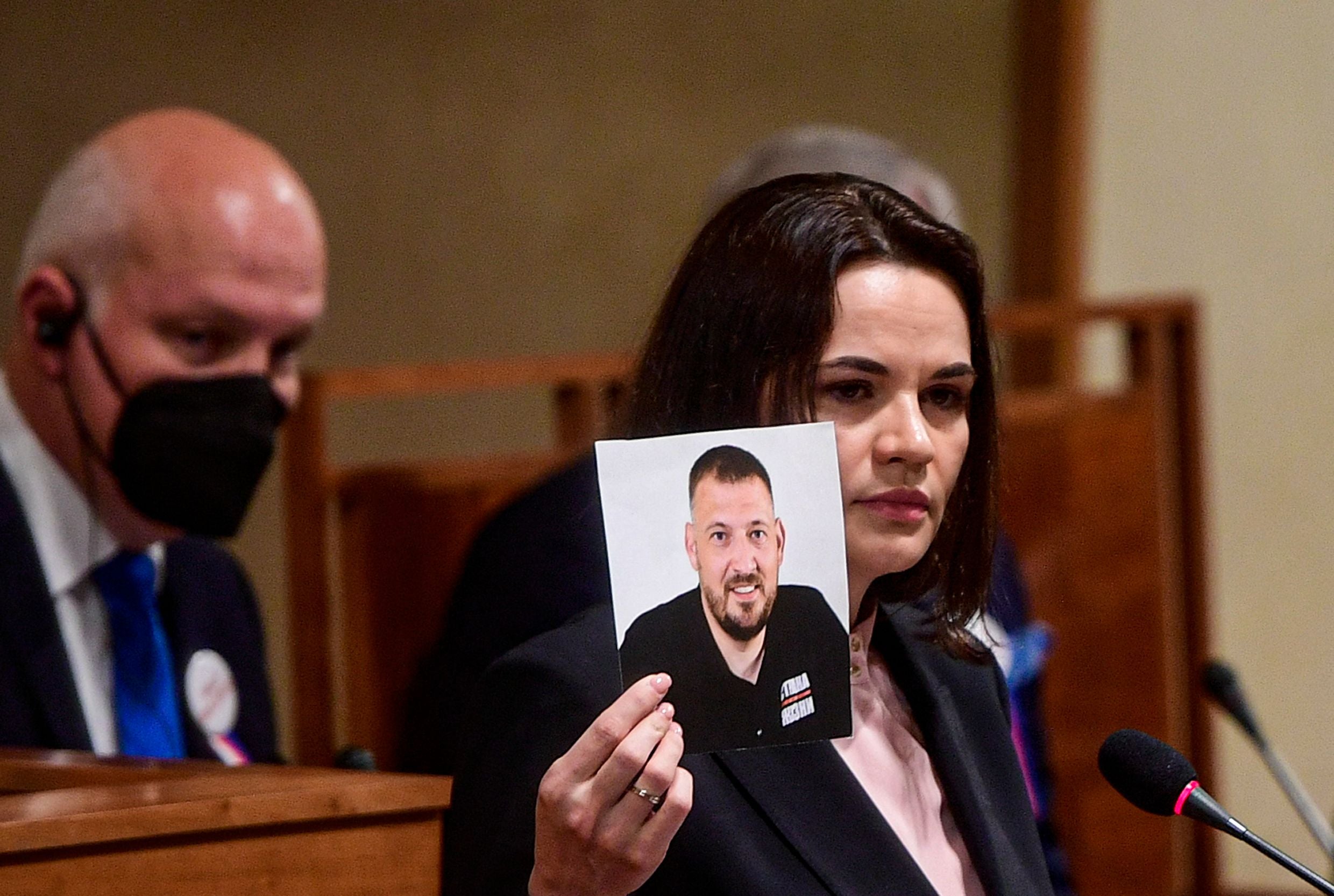 Belarusian opposition leader Svetlana Tikhanovskaya (R) holds a picture of her husband, the opposition figure jailed blogger Syarhai Tikhanovsky