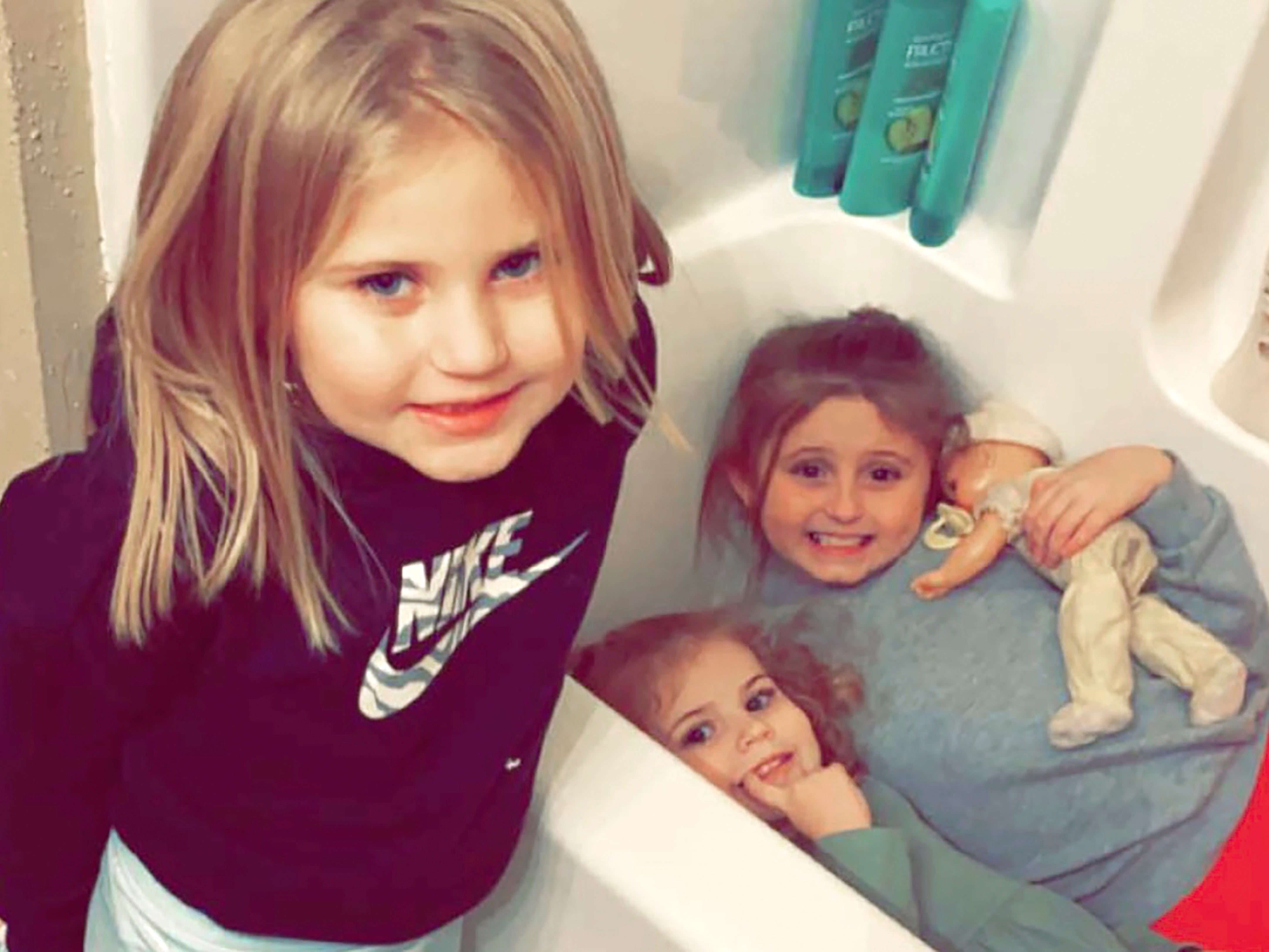 In this December 10, 2021, photo provided by Sandra Hooker, from left, Avalinn Rackley, 7, Alanna Rackley, 3, and Annistyn Rackley, 9, pose for a picture in a bathroom in their home near Caruthersville, Missouri