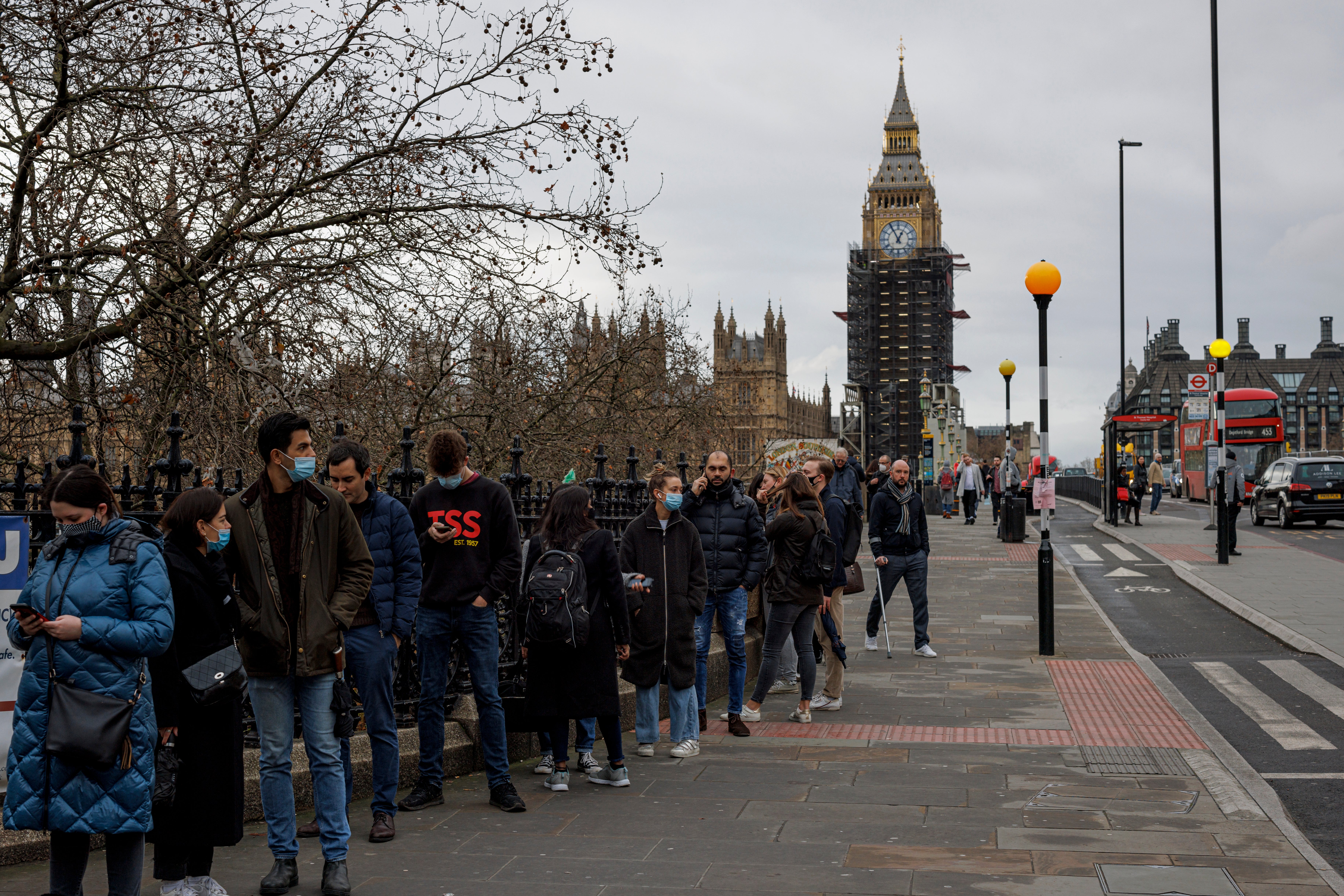 People queue outside a walk-in Covid vaccination centre at St Thomas's Hospital in Westminster on 13 December 2021