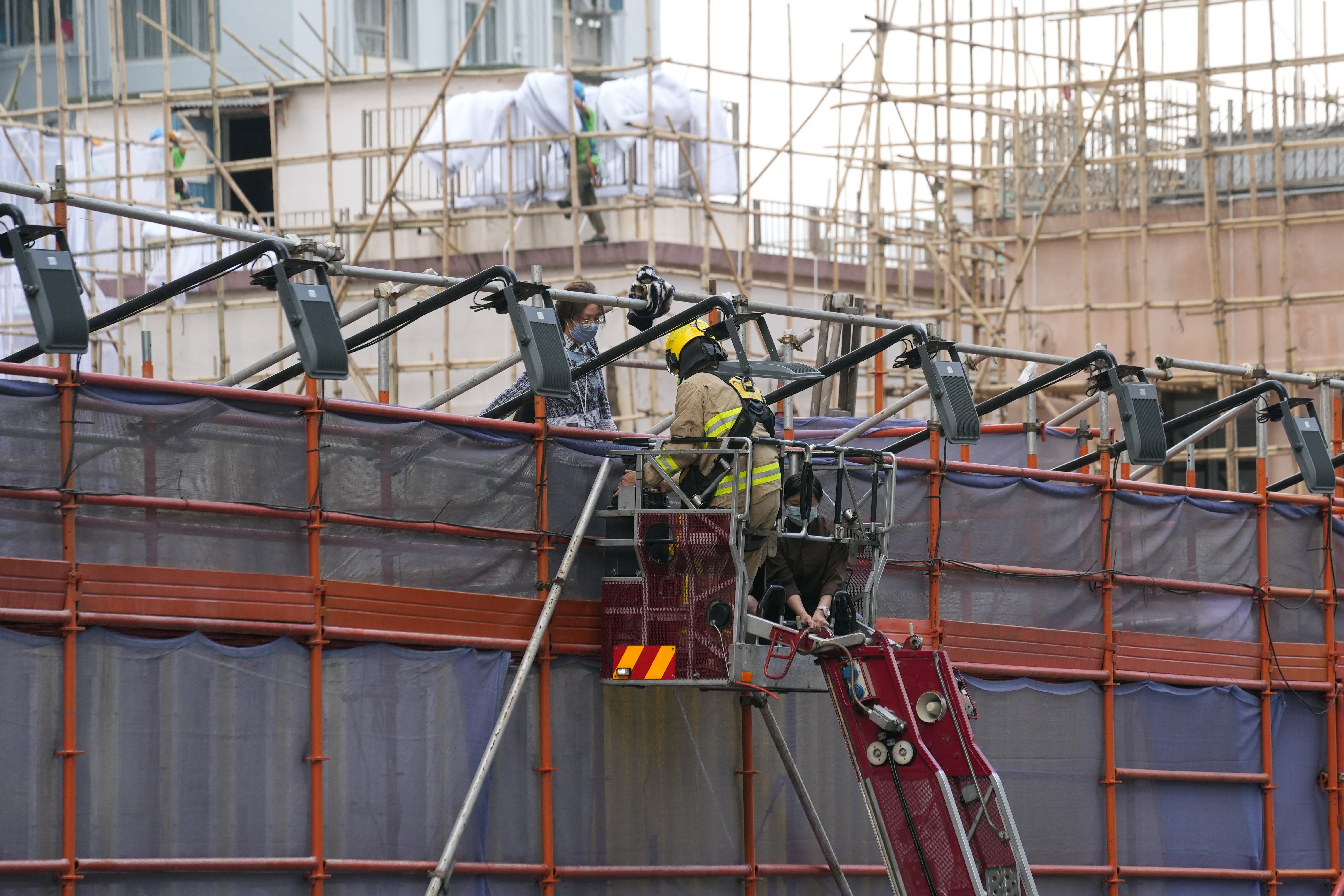 A firefighter rescues someone trapped in the building, which is currently undergoing renovation