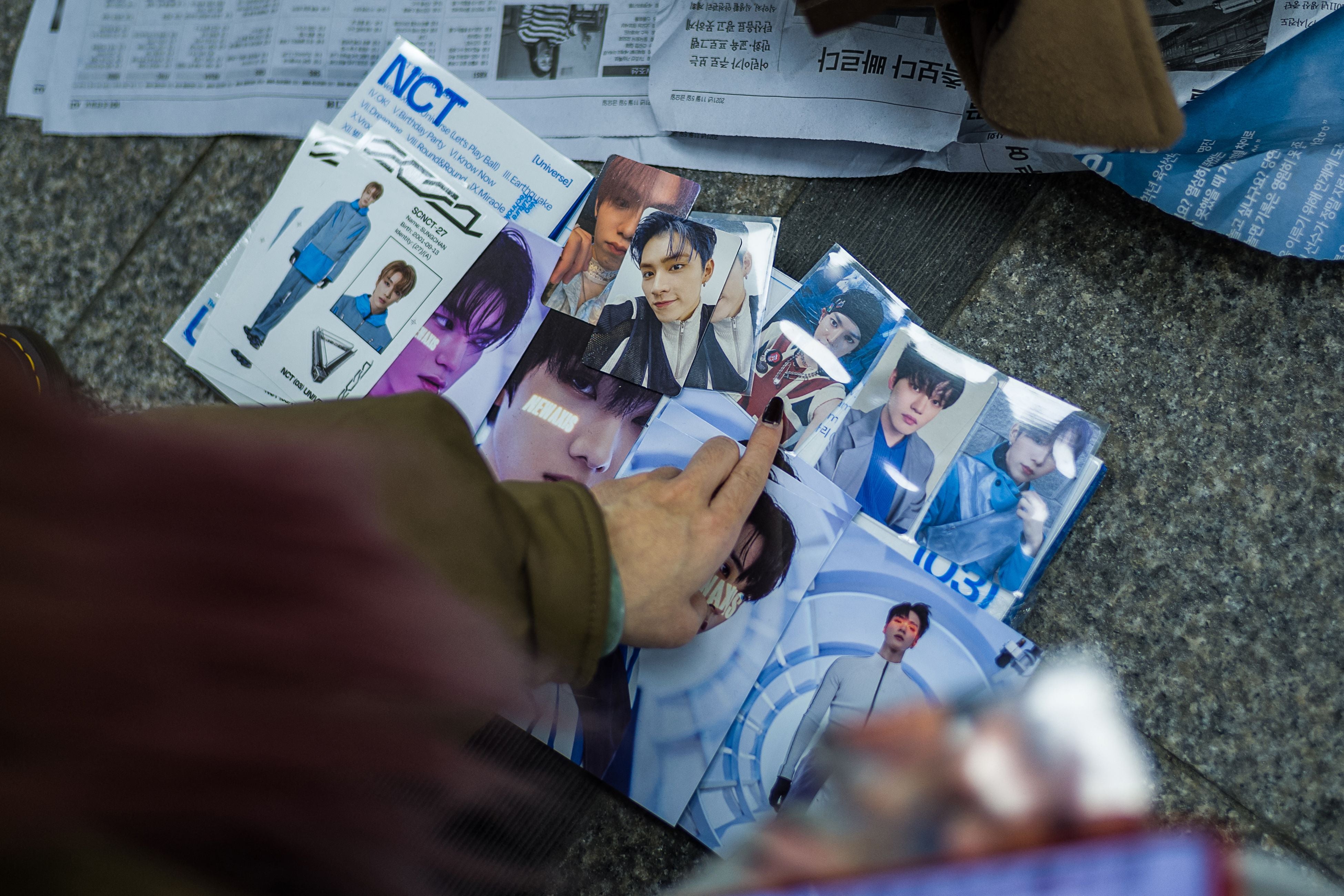 Fans of South Korean K-pop boy band NCT gather at the entrance of a metro station to swap collectable cards in Seoul