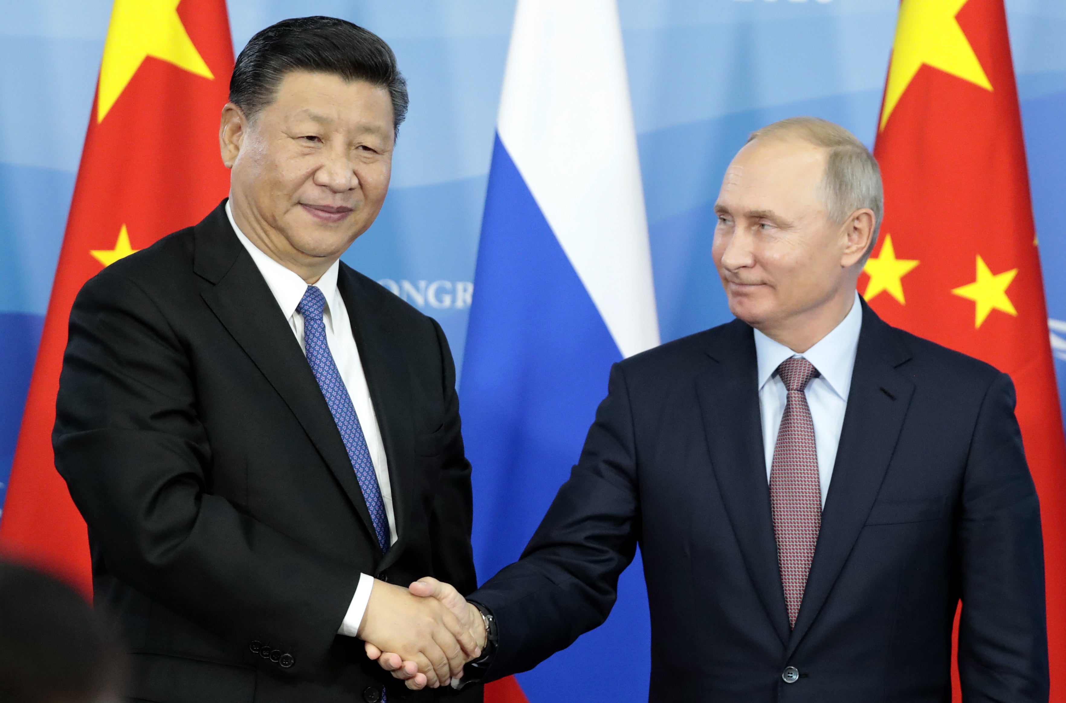 Vladimir Putin shakes hands with China’s president Xi Jinping