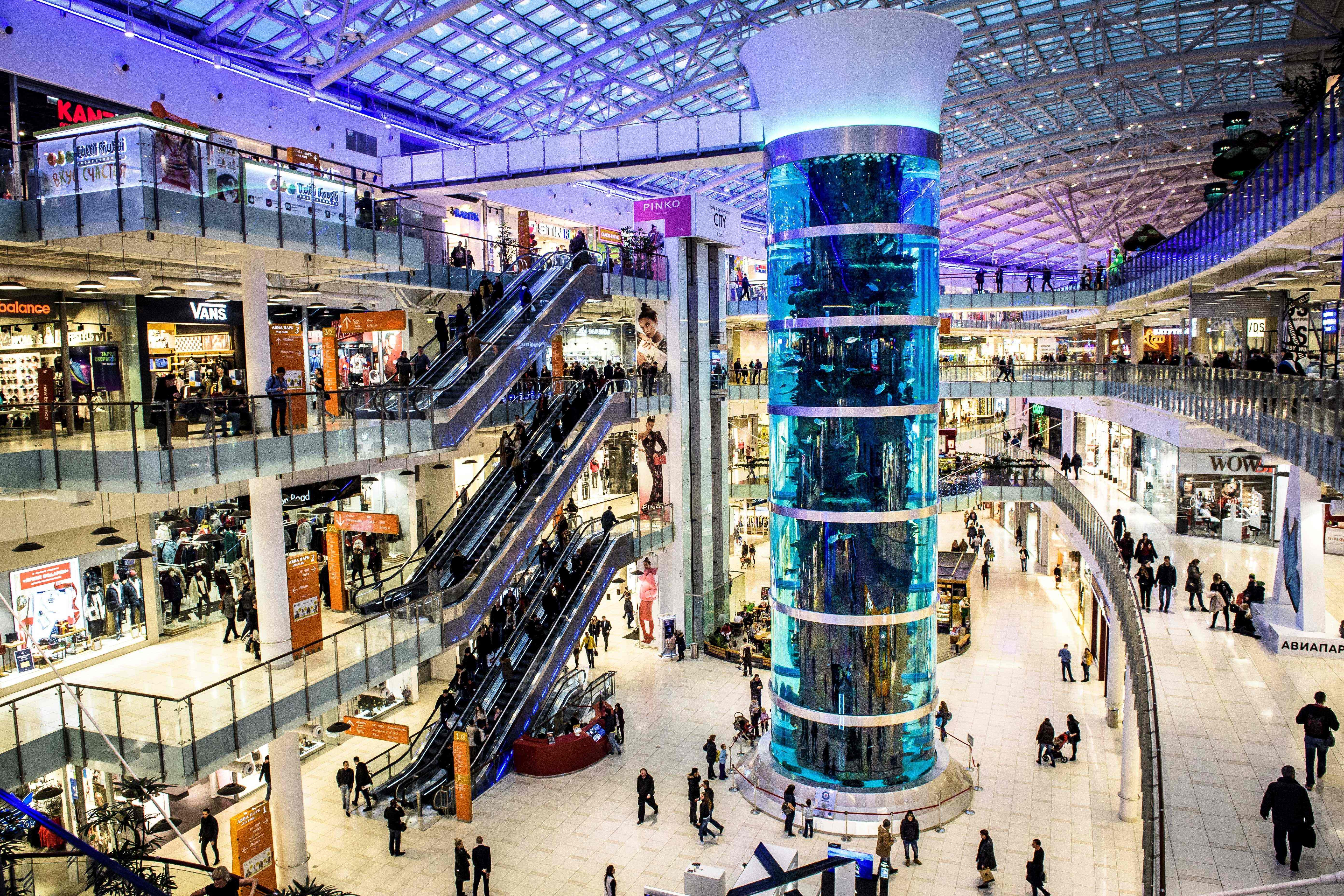 Shoppers walk next to the world’s tallest cylindrical aquarium at Moscow’s Aviapark shopping mall