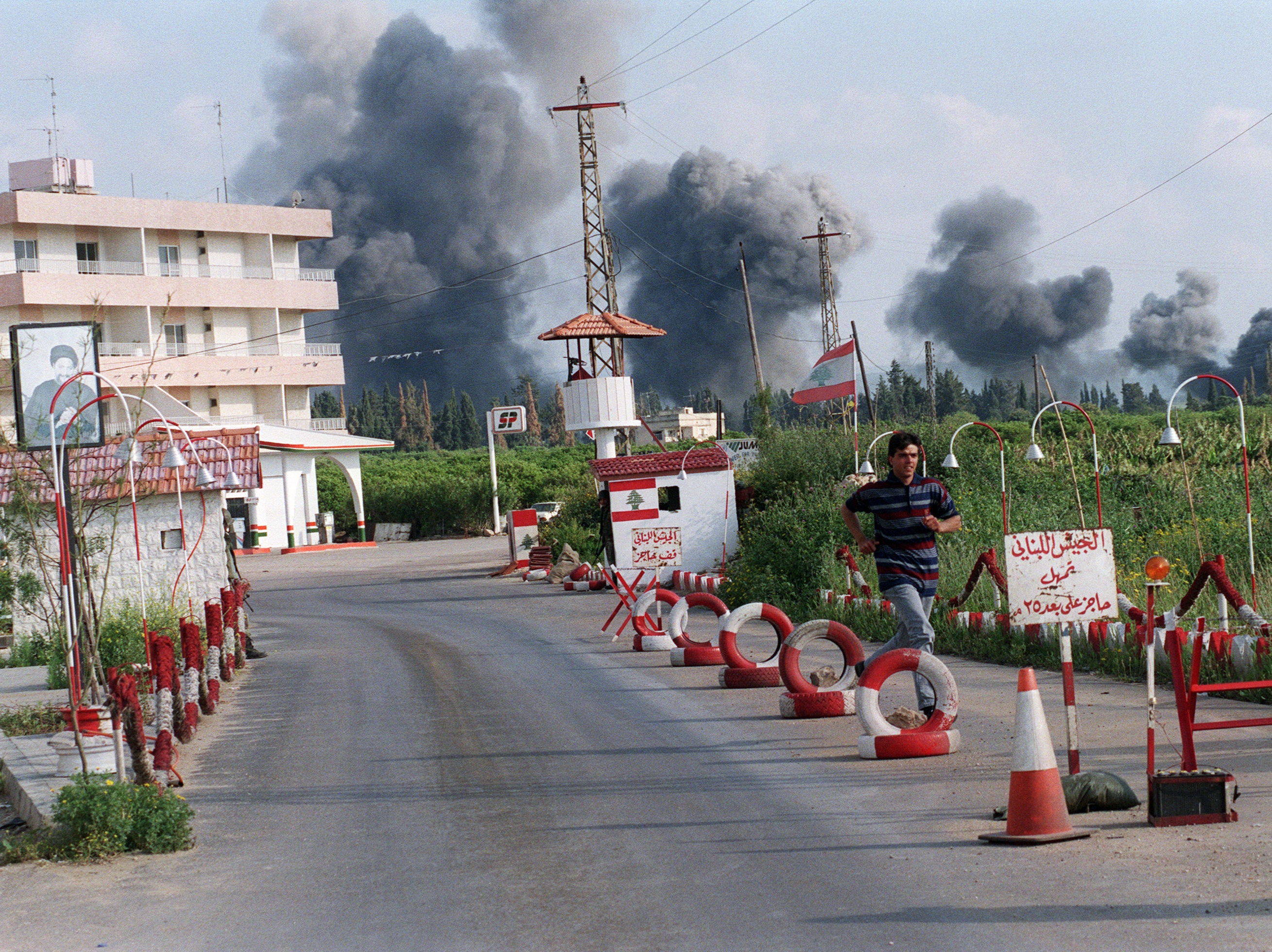 A teenager flees the site of an Israeli bombing in Cana, Lebanon