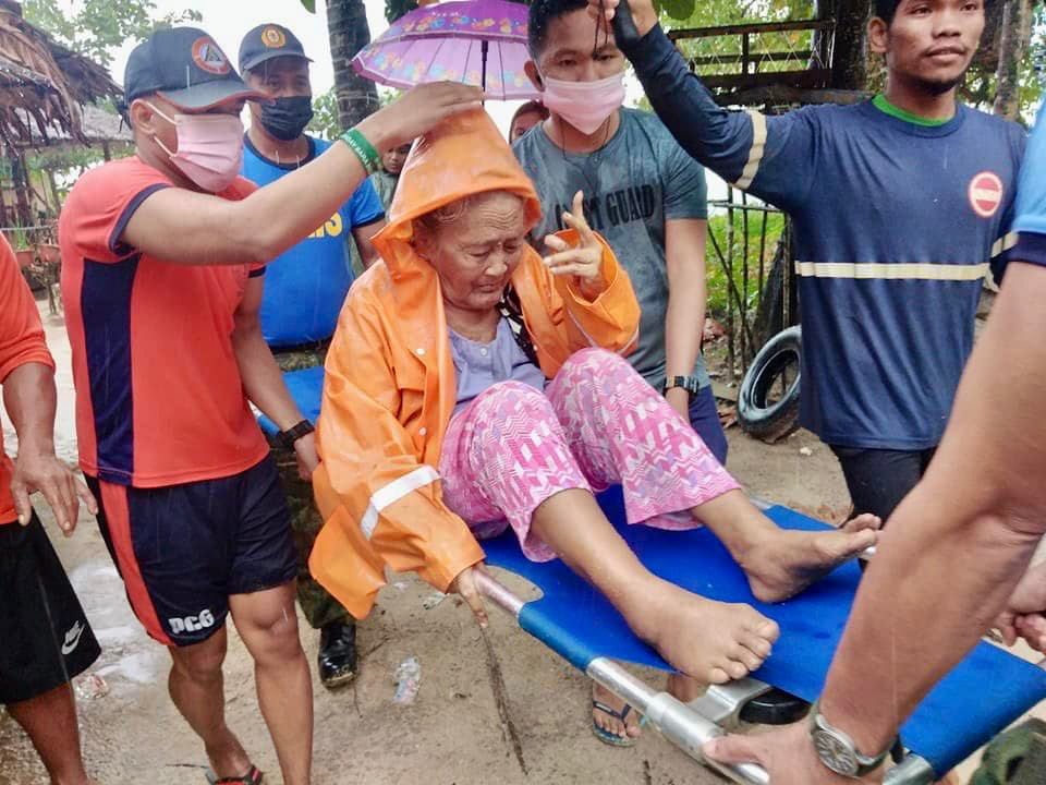 A handout picture made available by the Philippine Coast Guard (PCG) shows PCG personnel evacuating residents living along a coastline in the Caraga region, southern Philippines