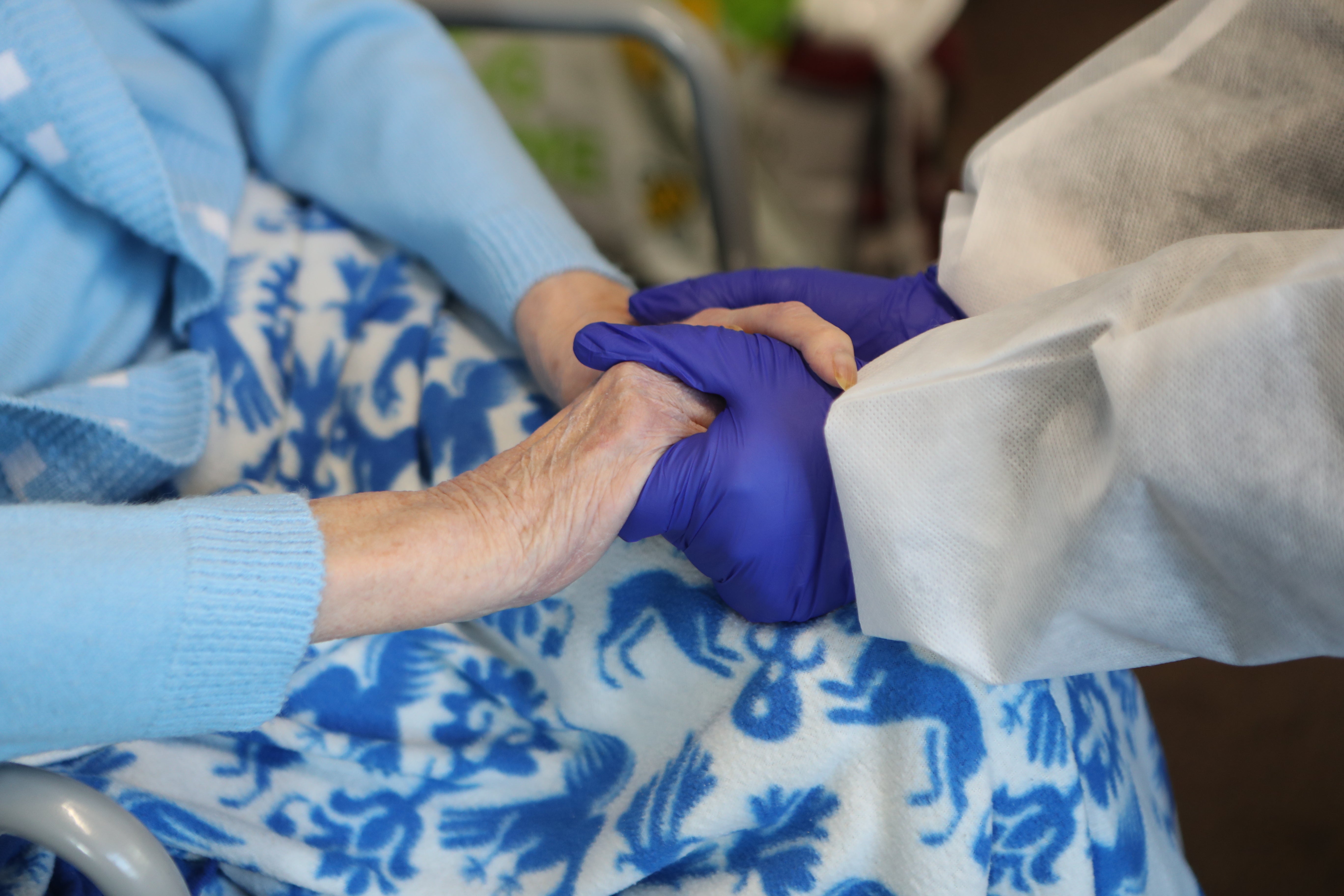 A care home resident sits with her friend during a Christmas Day visit at a care home in 2020 (Danny Lawson/PA)