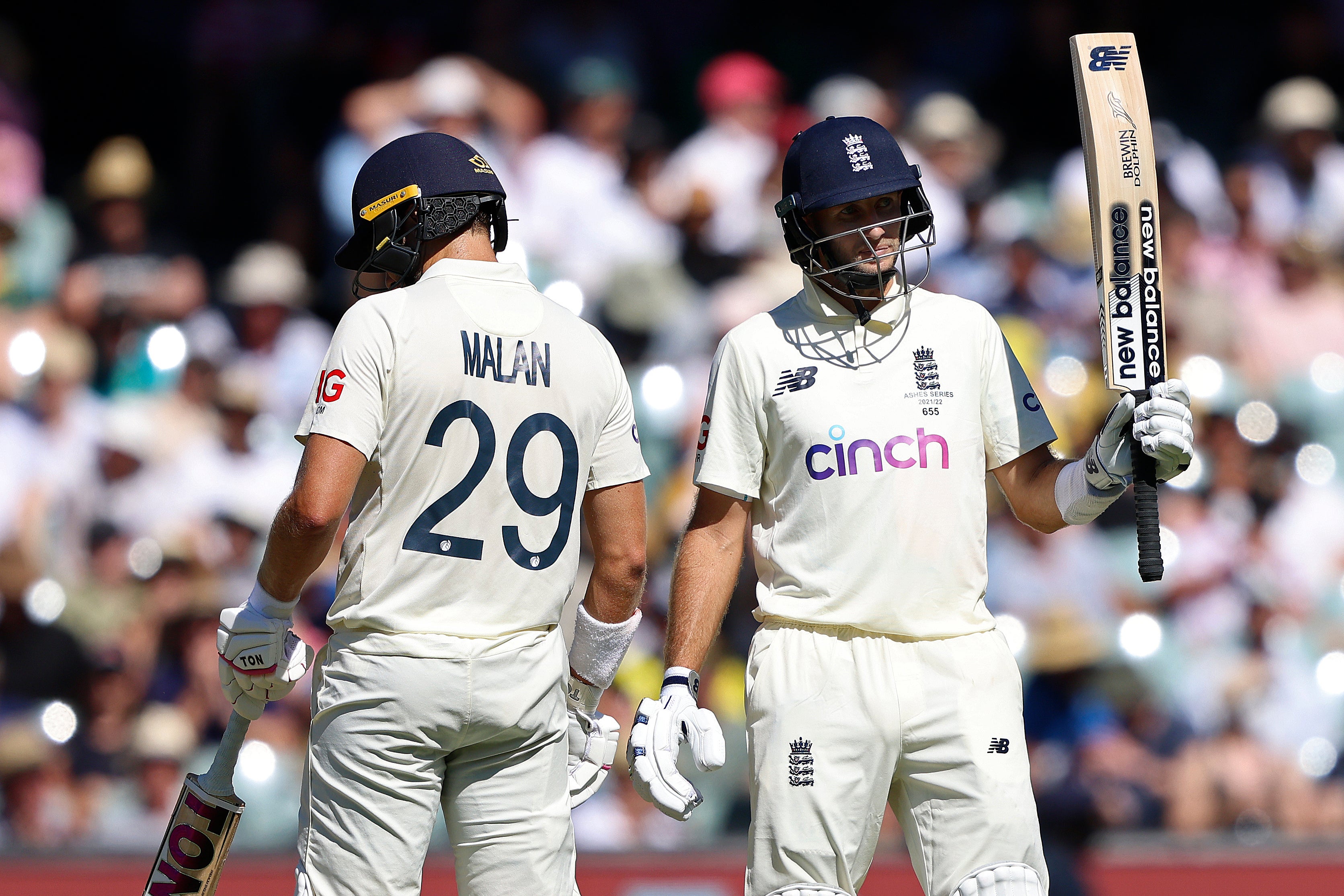 Joe Root, right, raises his bat after reaching his half-century (James Elsby/AP)