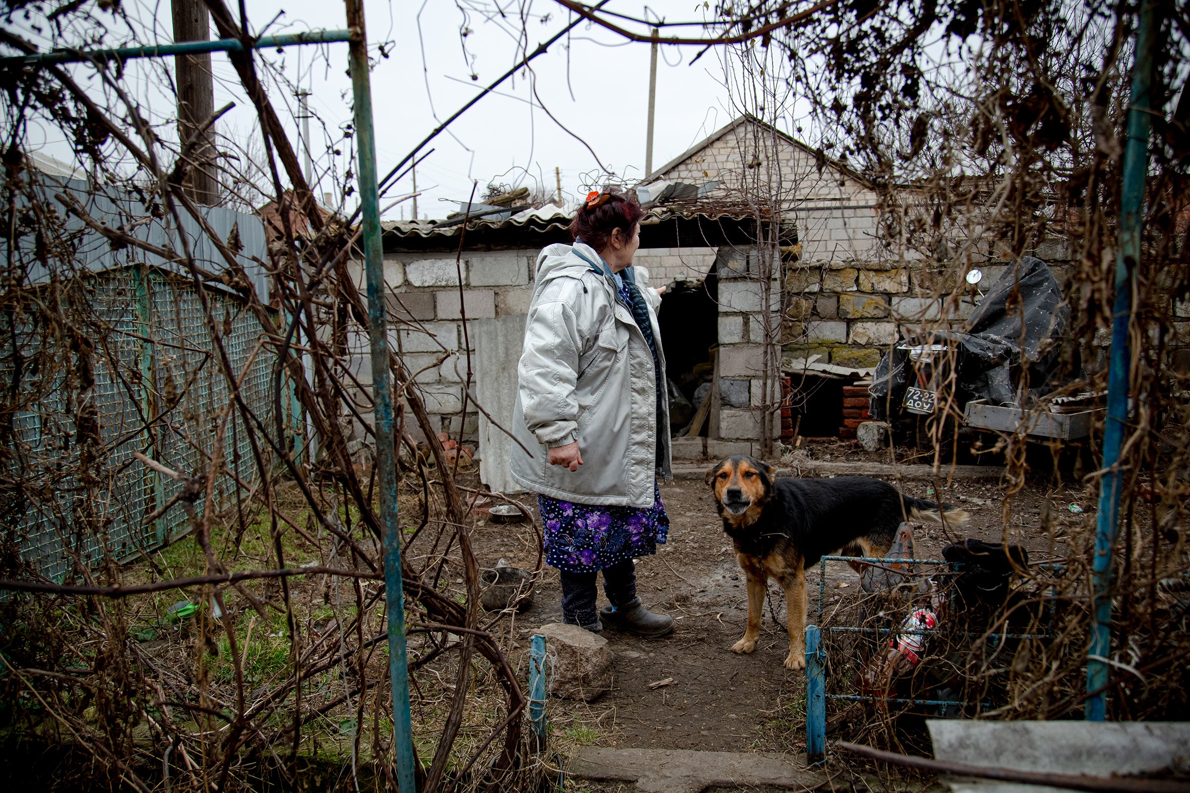 Svetlana Haytulova with her dog at their damaged home