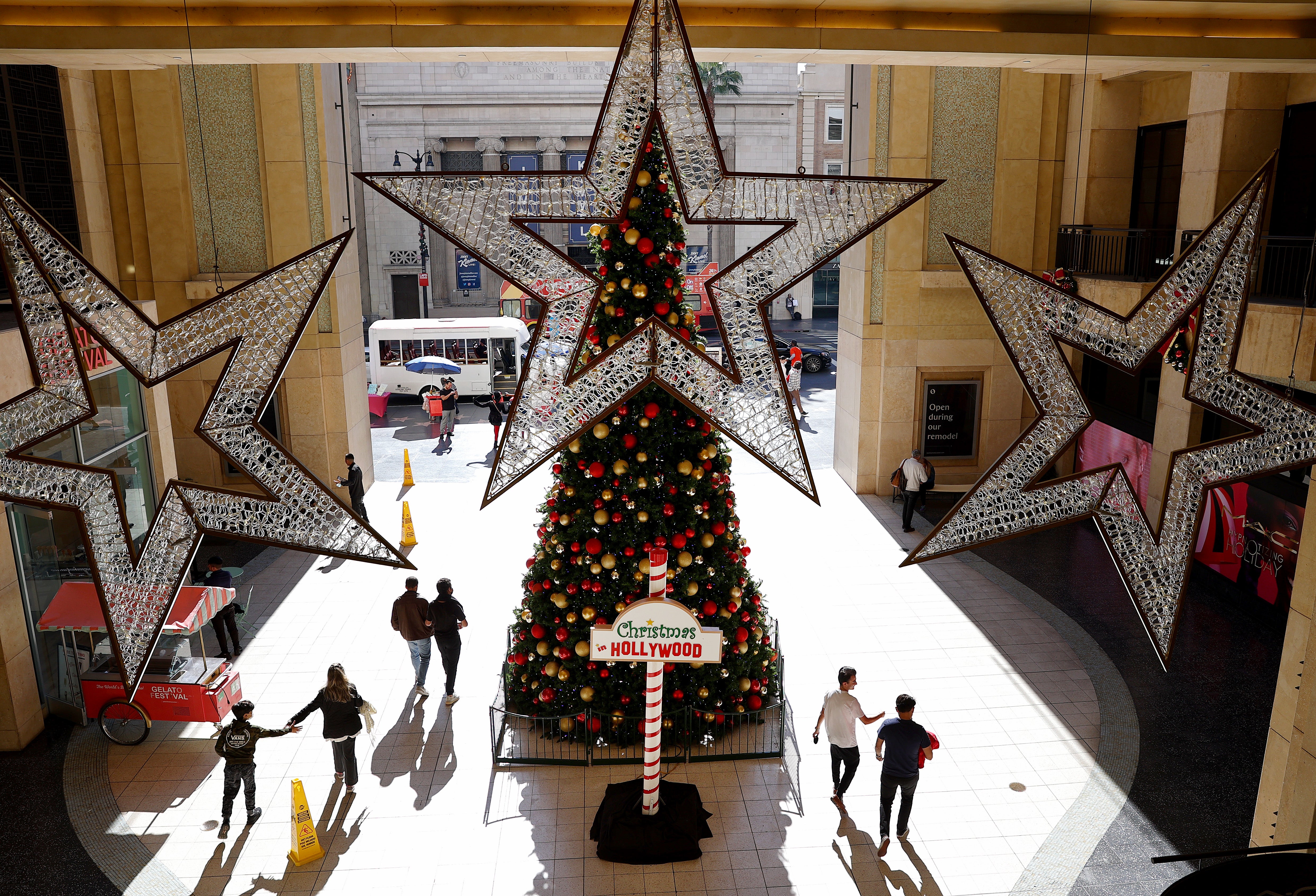 People walk past a Christmas tree on display at Hollywood & Highland on 17 December 2021 in Los Angeles, California