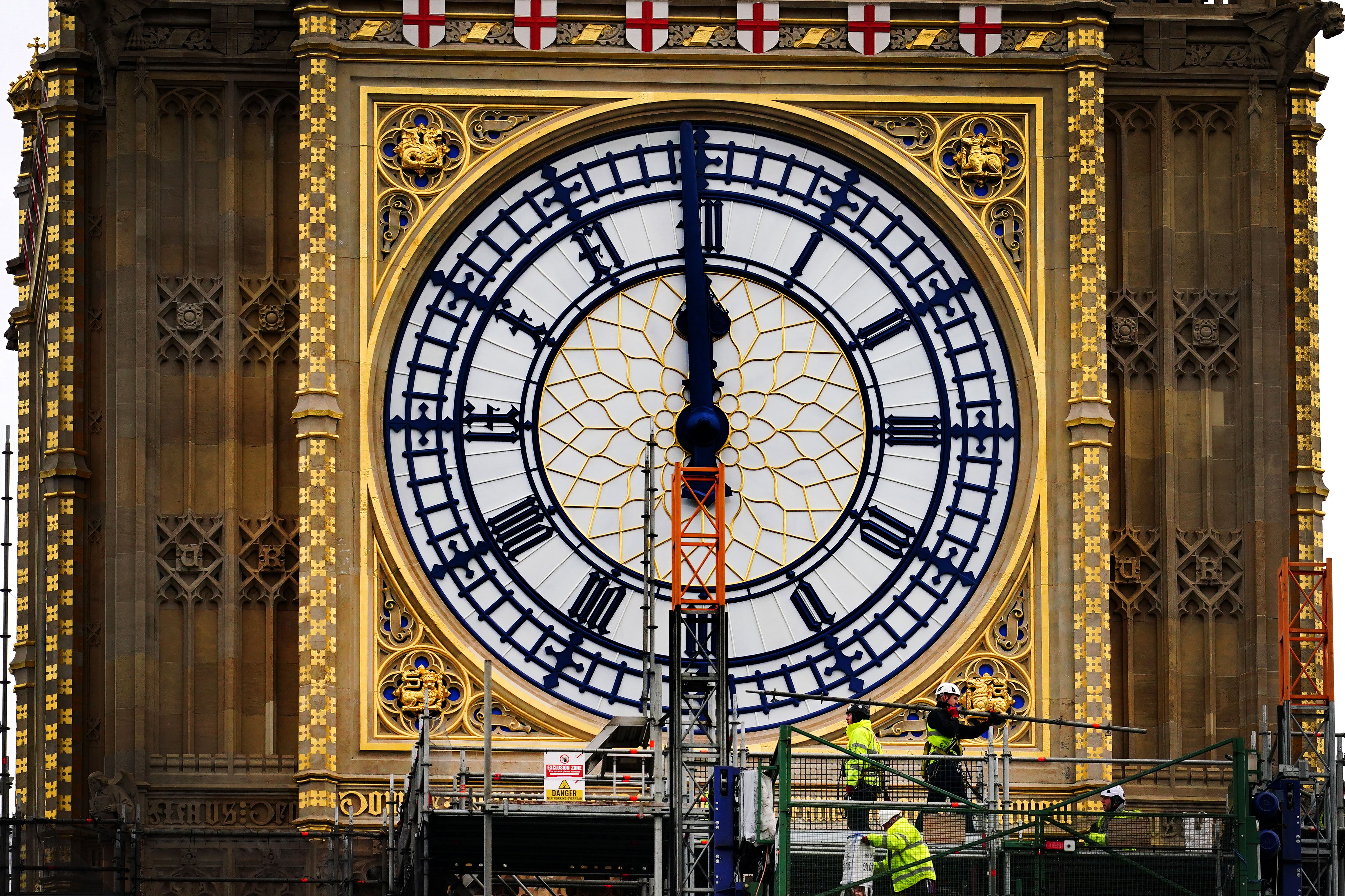 Construction workers remove the scaffolding from the restored west dial of the clock on Elizabeth Tower, known as Big Ben, at the Palace of Westminster (Victoria Jones/PA)