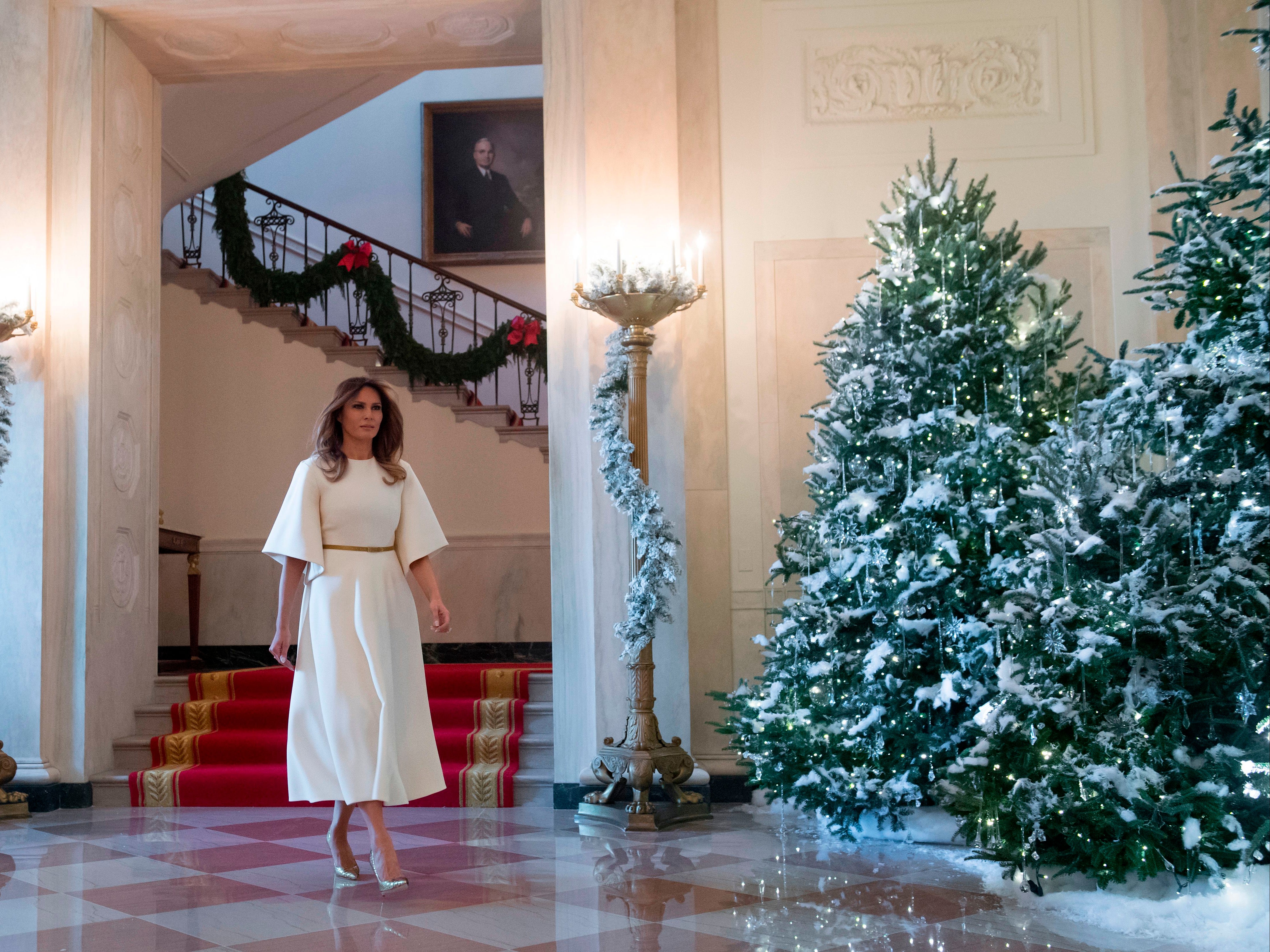 First Lady Melania Trump walks through the Grand Foyer as she tours Christmas decorations at the White House in Washington, DC, November 27, 2017