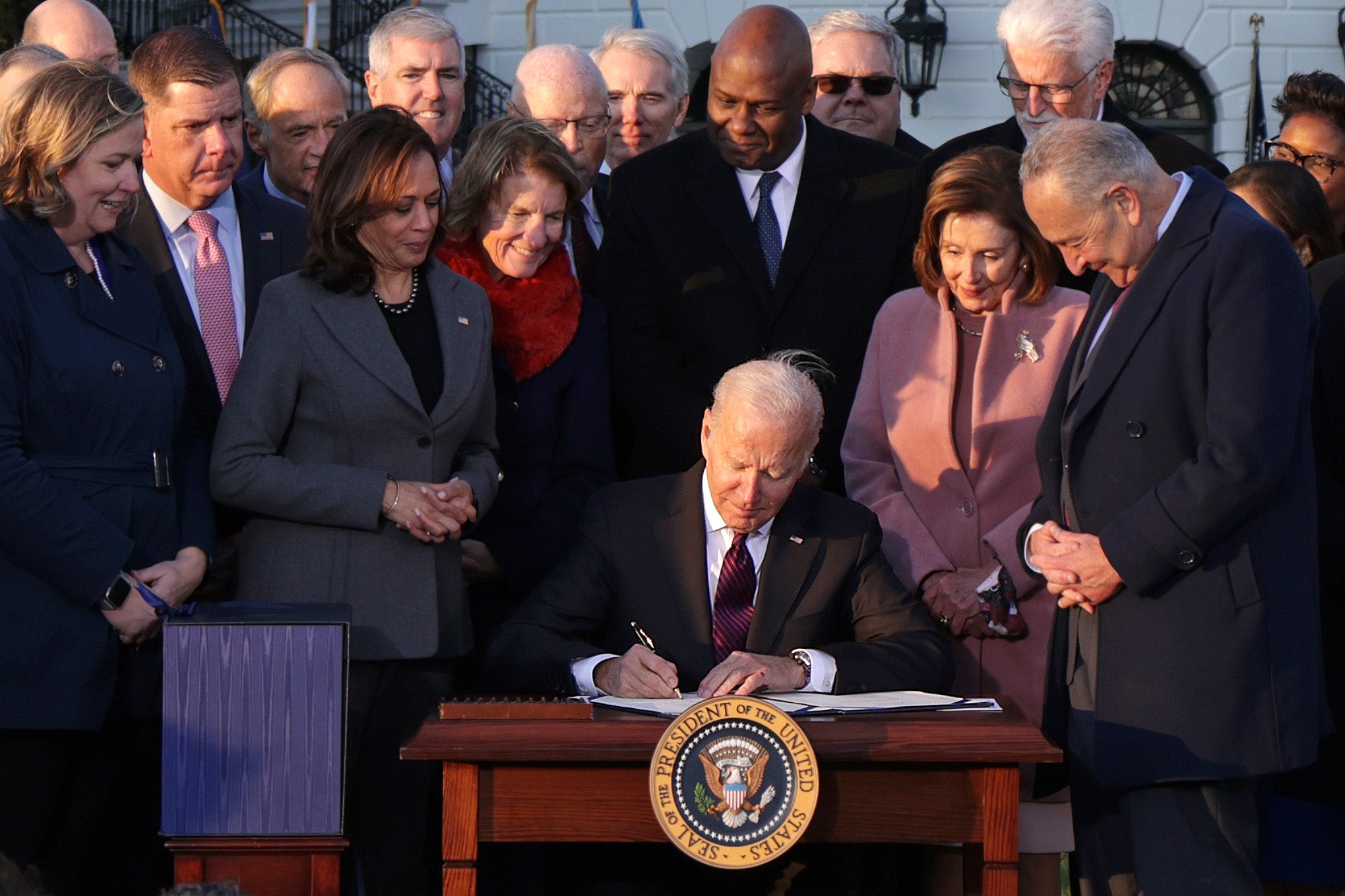 US President Joe Biden signing the bipartisan infrastructure bill in a ceremony outside the White House on 15 November. Negotiations went on for months amid disagreements.