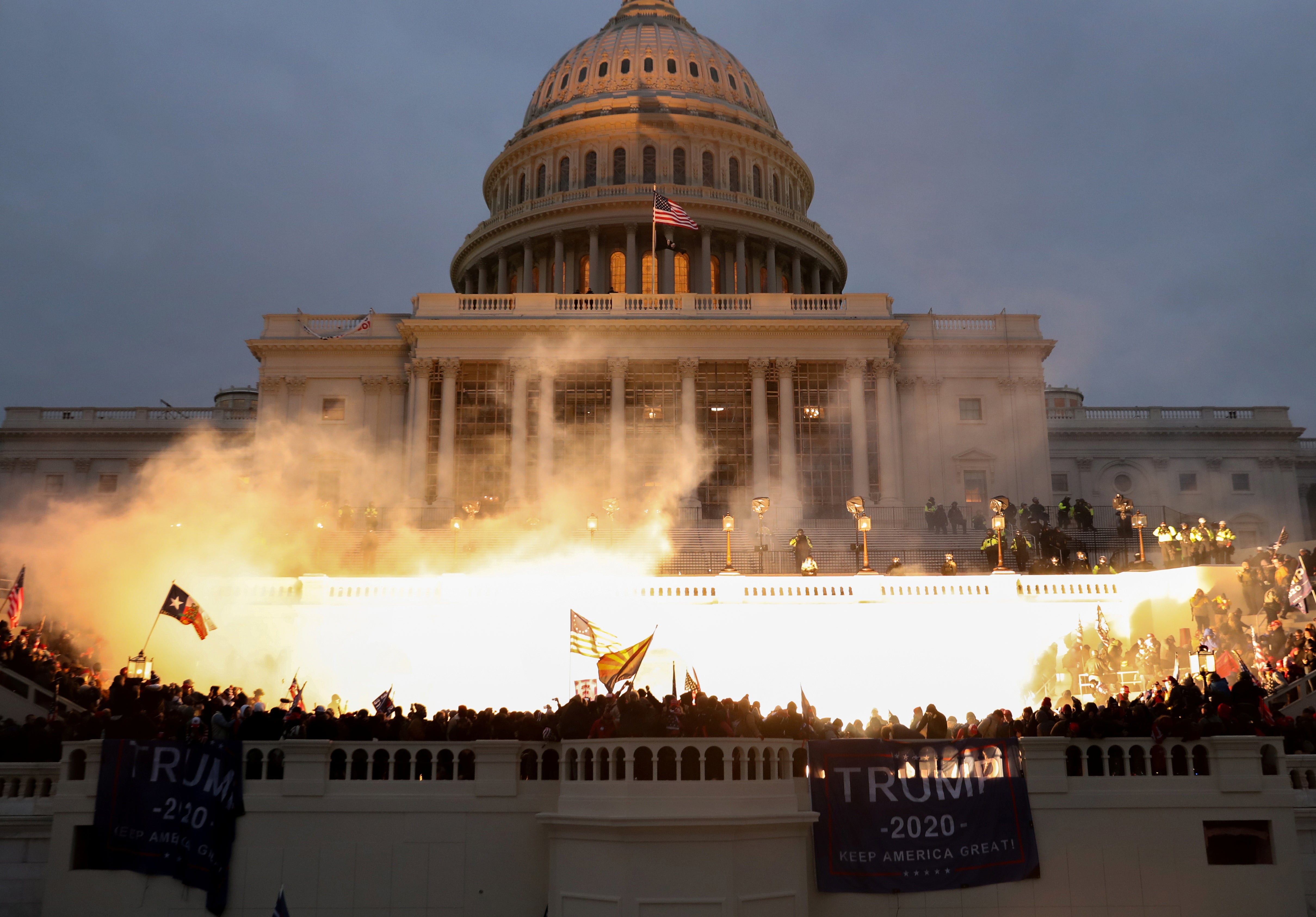 Hundreds of alleged Trump supporters encircled the US Capitol Building on 6 January, as police munition caused a flame – lighting up the crowd.