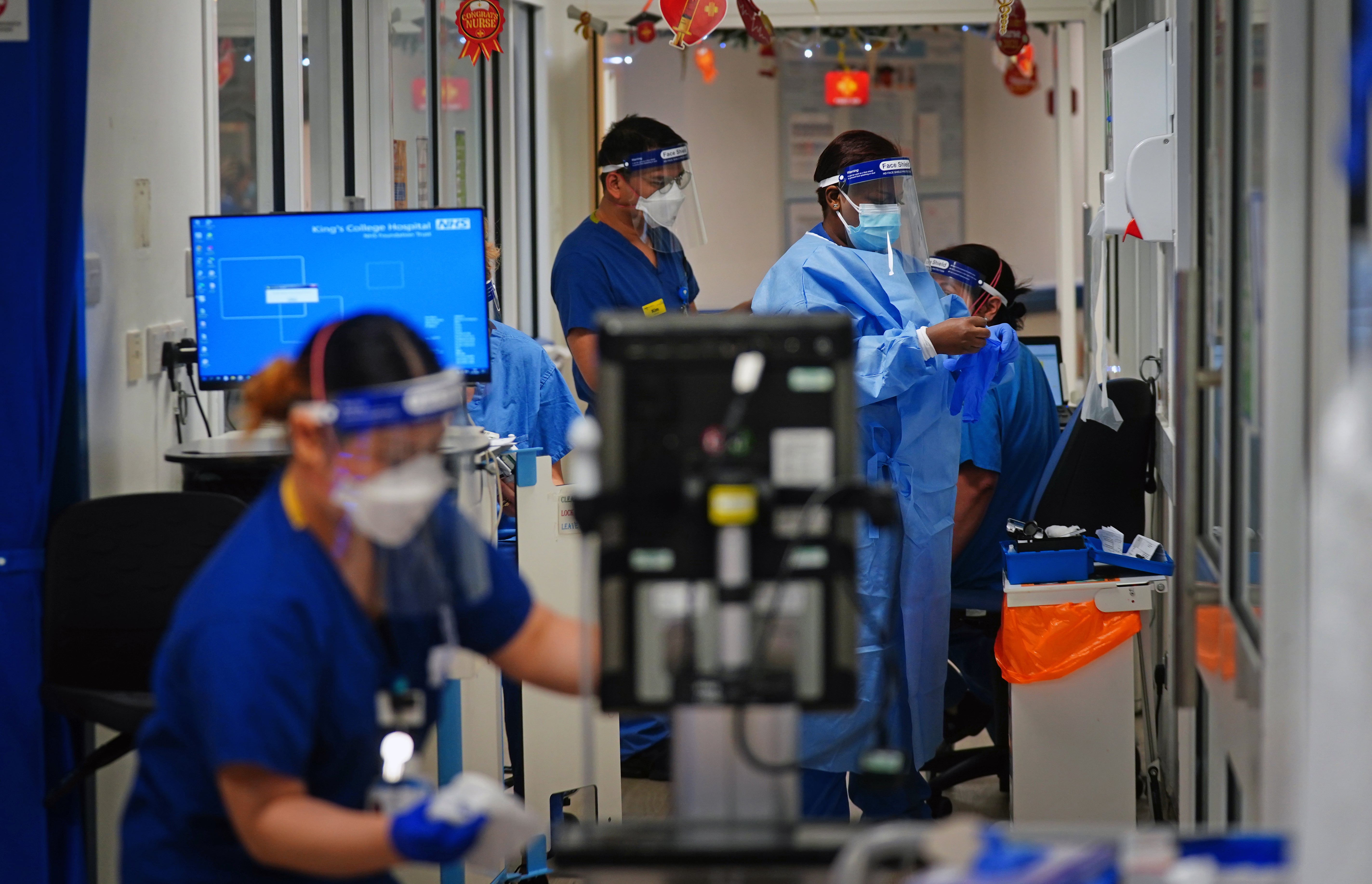 Medical staff wearing PPE work in a corridor on a ward for Covid patients at King’s College Hospital, in south east London (Victoria Jones/PA)