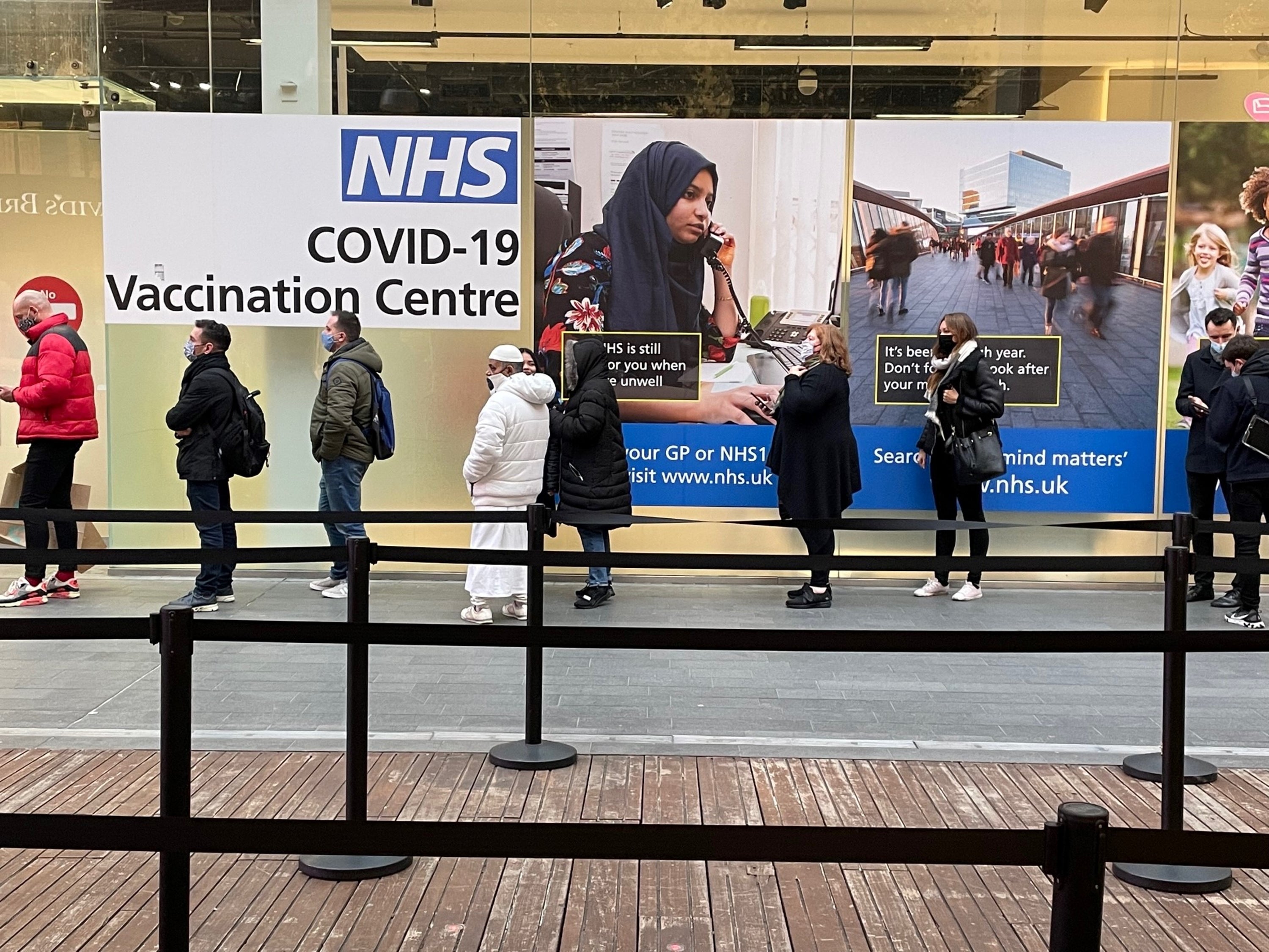 People queuing at a Covid-19 vaccination centre at the Westfield shopping centre in Stratford, east London (Jonathan Brady/PA)