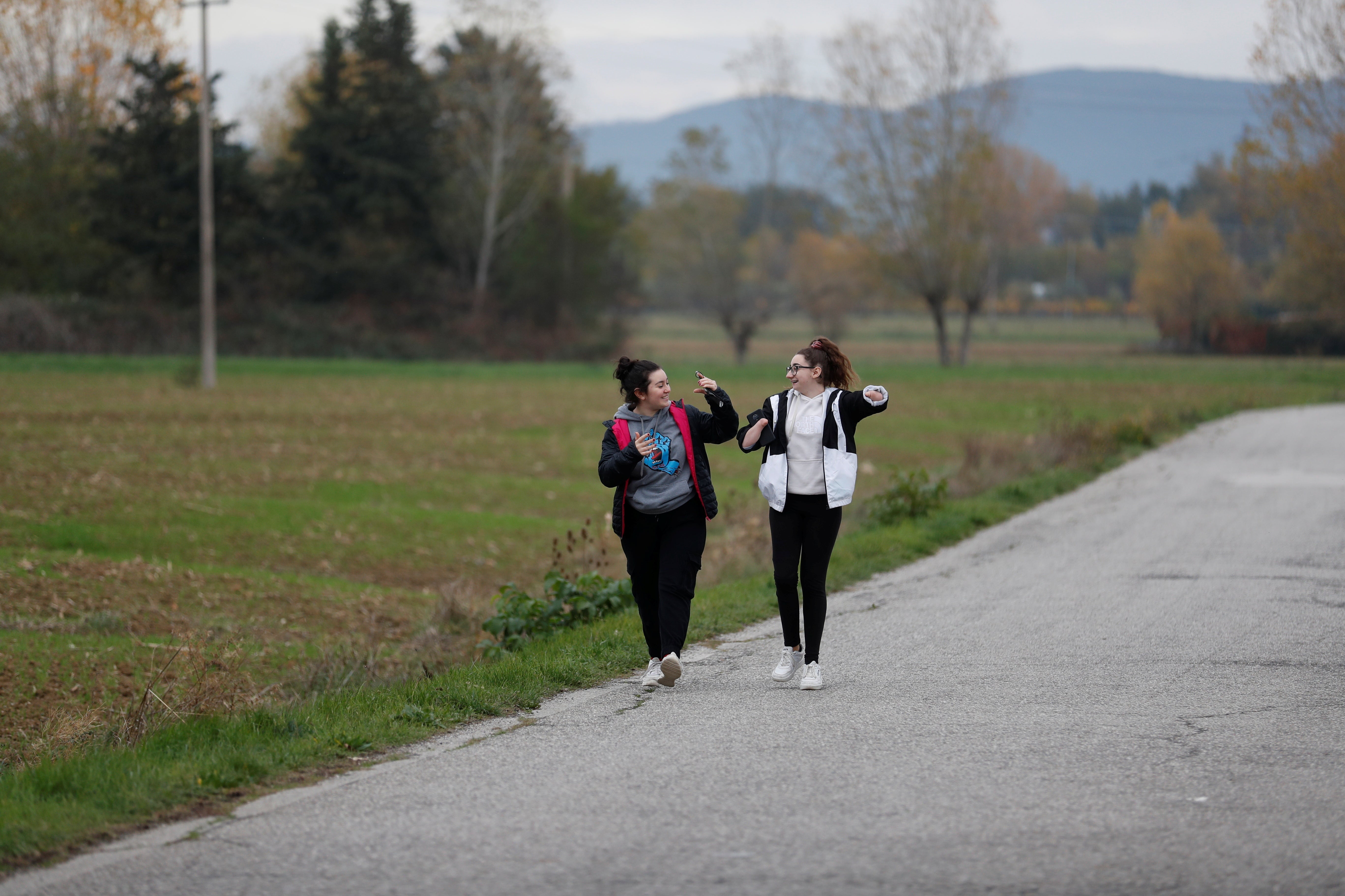 Francesca sings and dances with her younger cousin Anna as they walk along a street in Magione