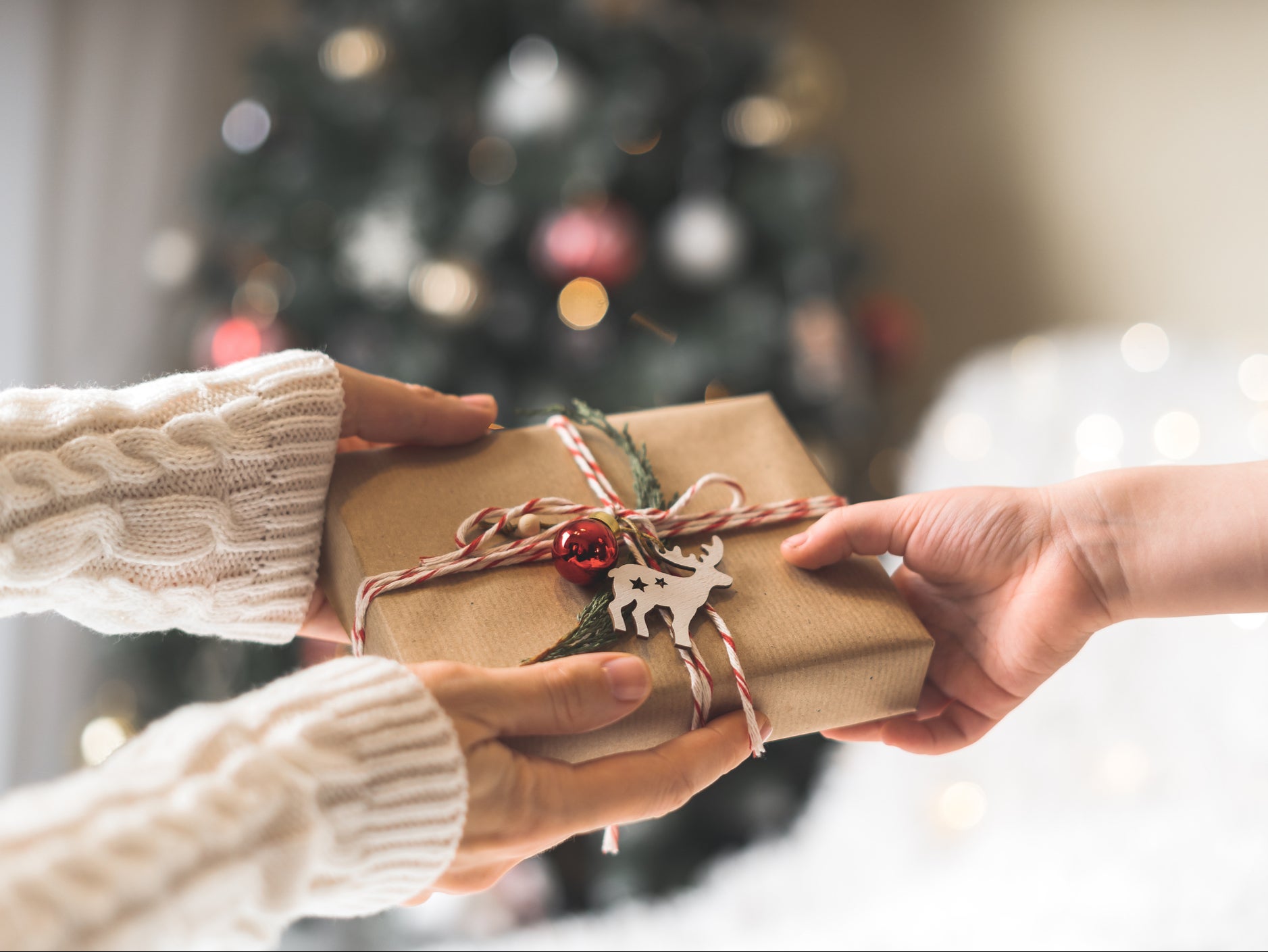 A person gives a child a gift at Christmas