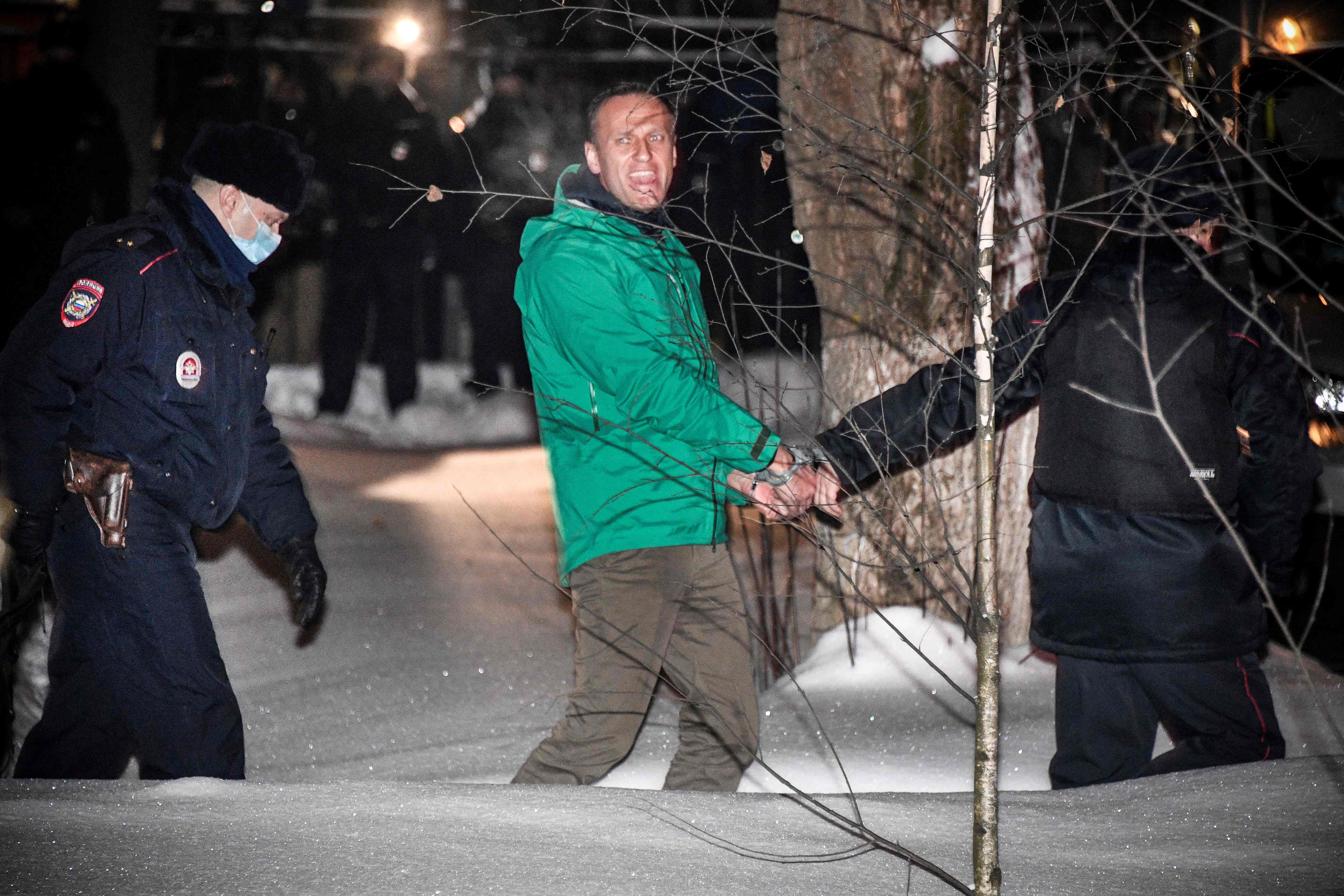 Opposition leader Alexei Navalny is escorted out of a police station on January 18, 2021