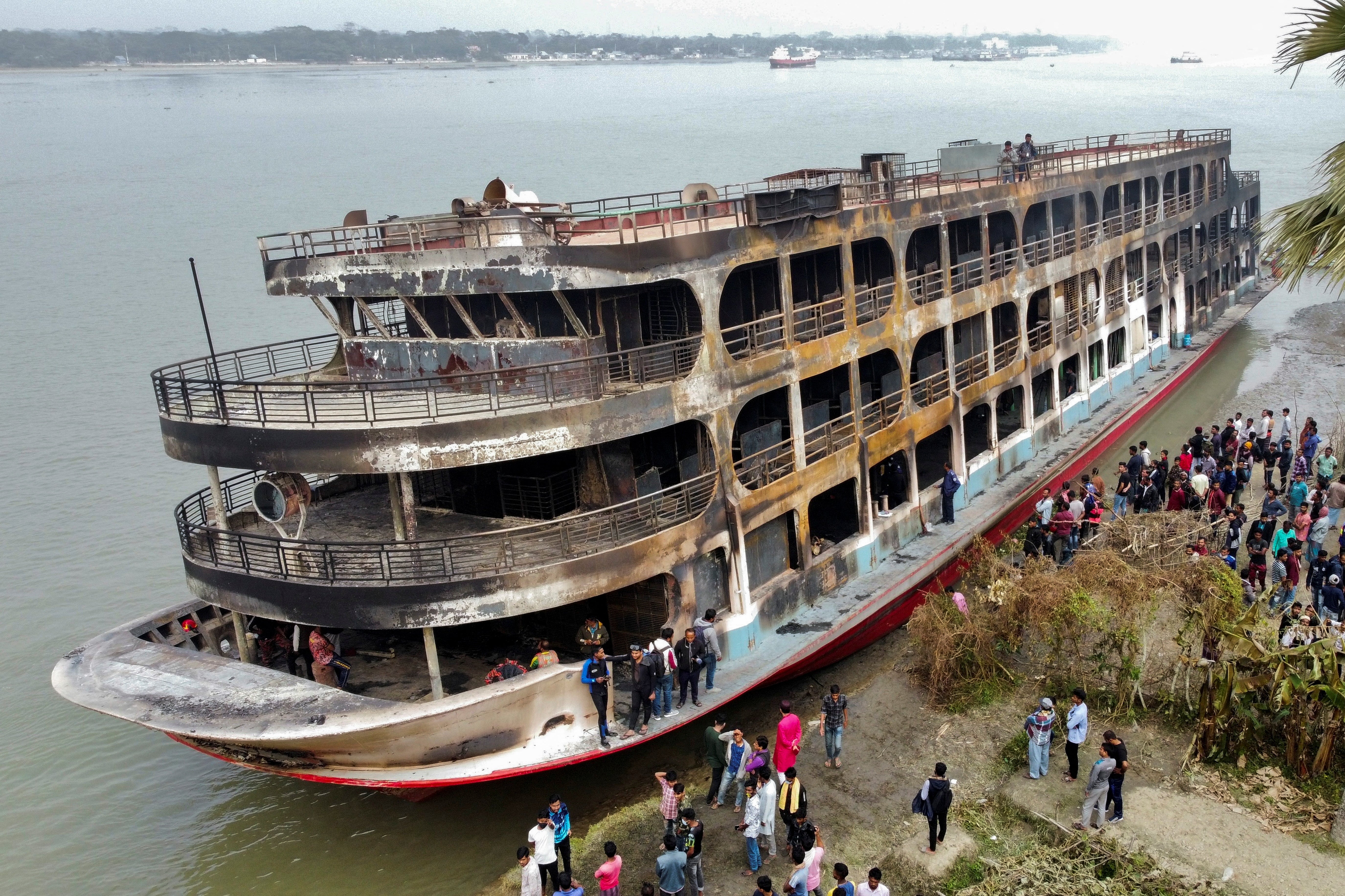 A burnt passenger ferry is seen anchored on the bank of Sugandha river, after a fire that killed at least 38 in Jhalalathi, Bangladesh on Friday