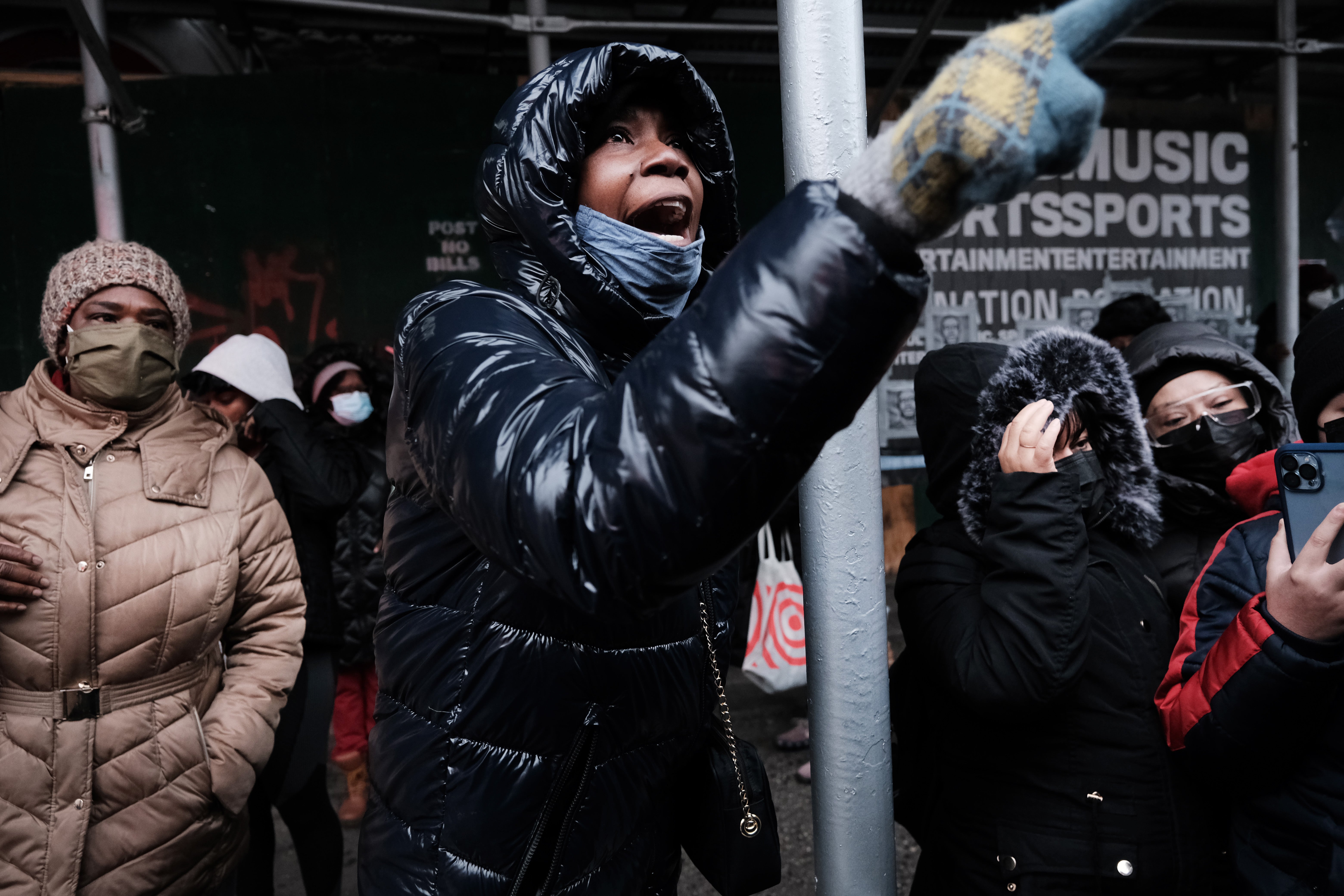 People form a large crowd as they attempt to receive COVID-19 testing kits from city workers distributing the kits along Flatbush Avenue on Christmas Eve