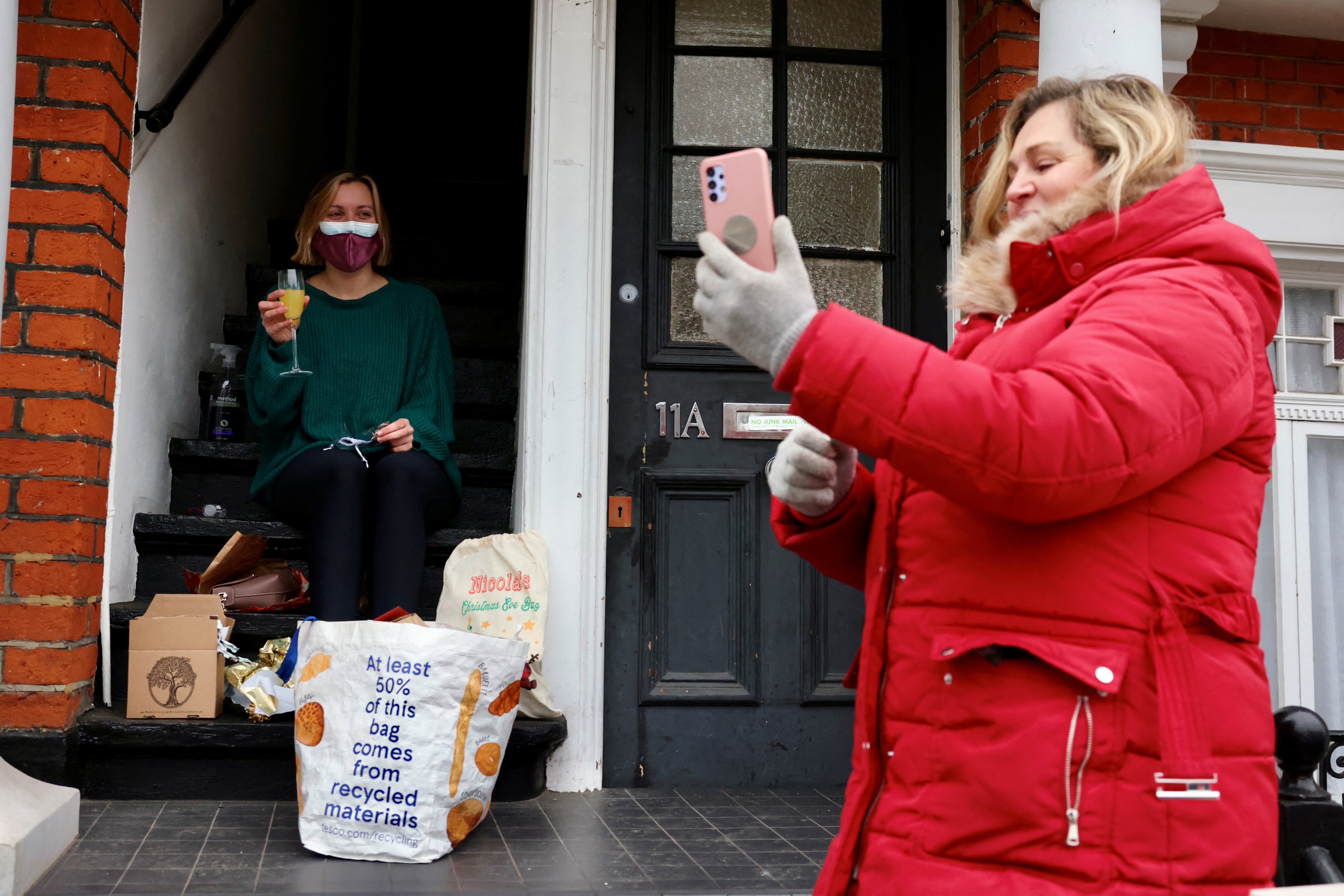 Nicola Summerville, who is self-isolating with Covid, sits on her doorstep as her mum Tracey Dunn, who delivered gifts and food