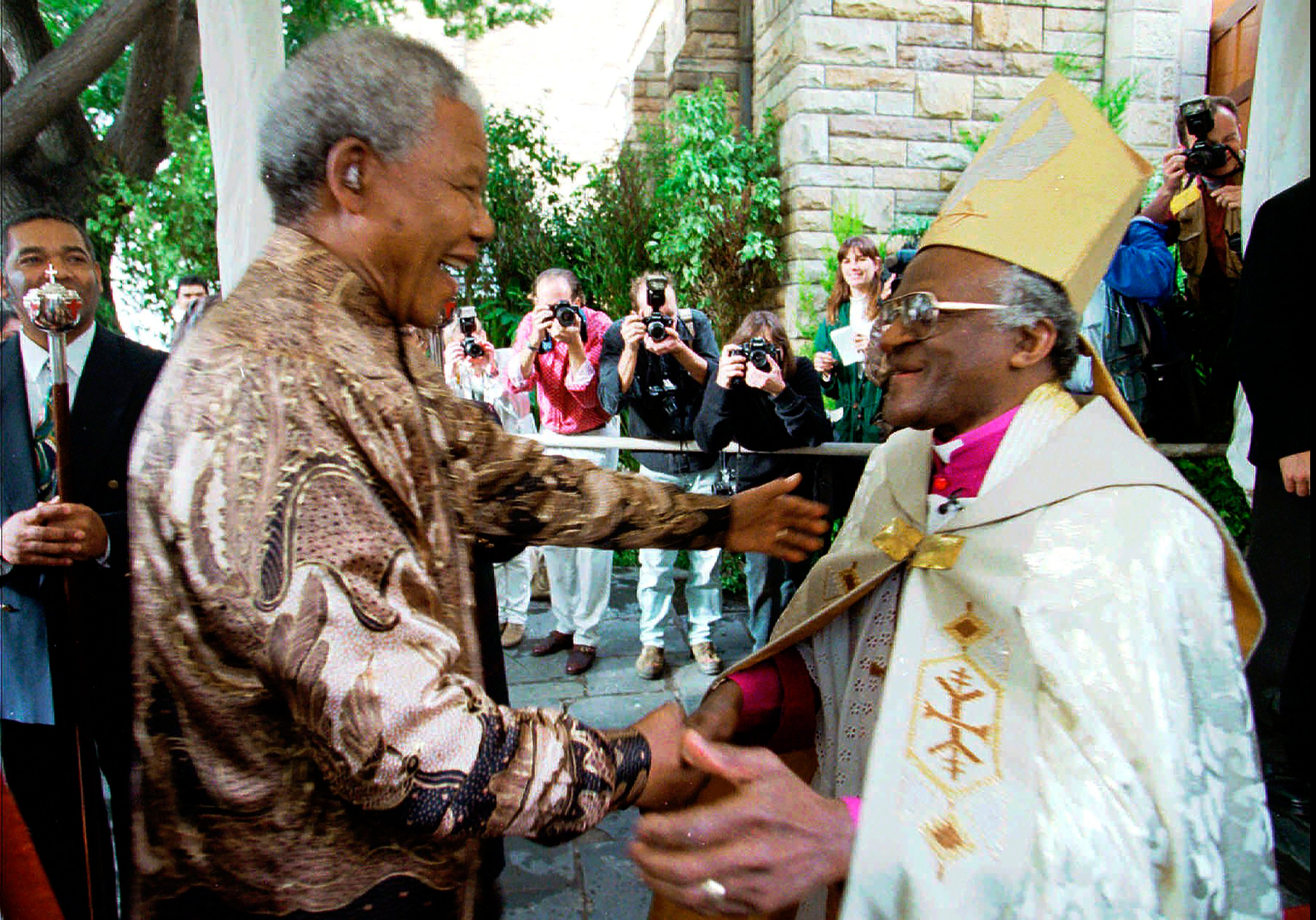 Archbishop Desmond Tutu greets President Nelson Mandela at a service in Cape Town in 1996