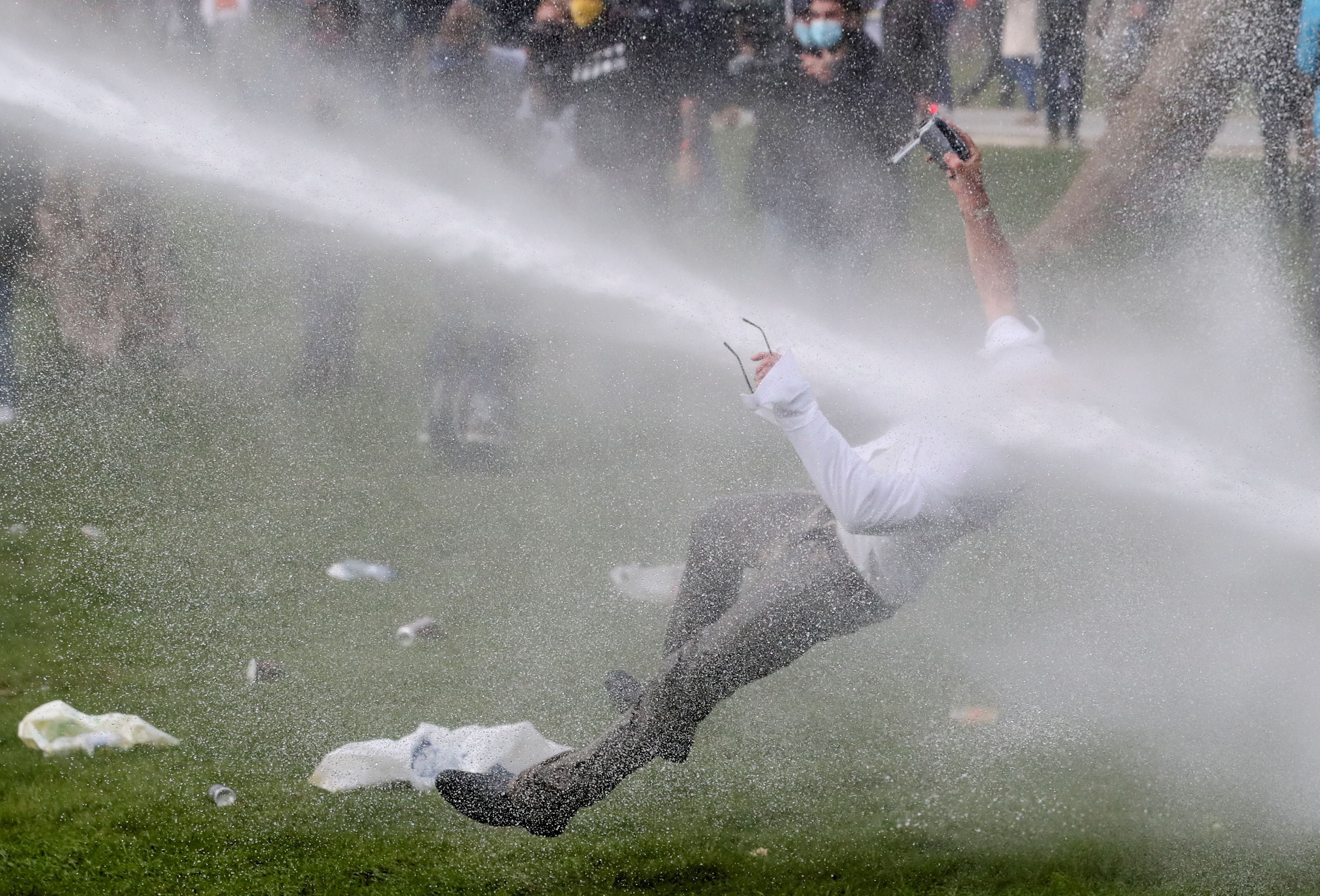 A man is doused by a water cannon during protests against Belgium’s Covid restrictions