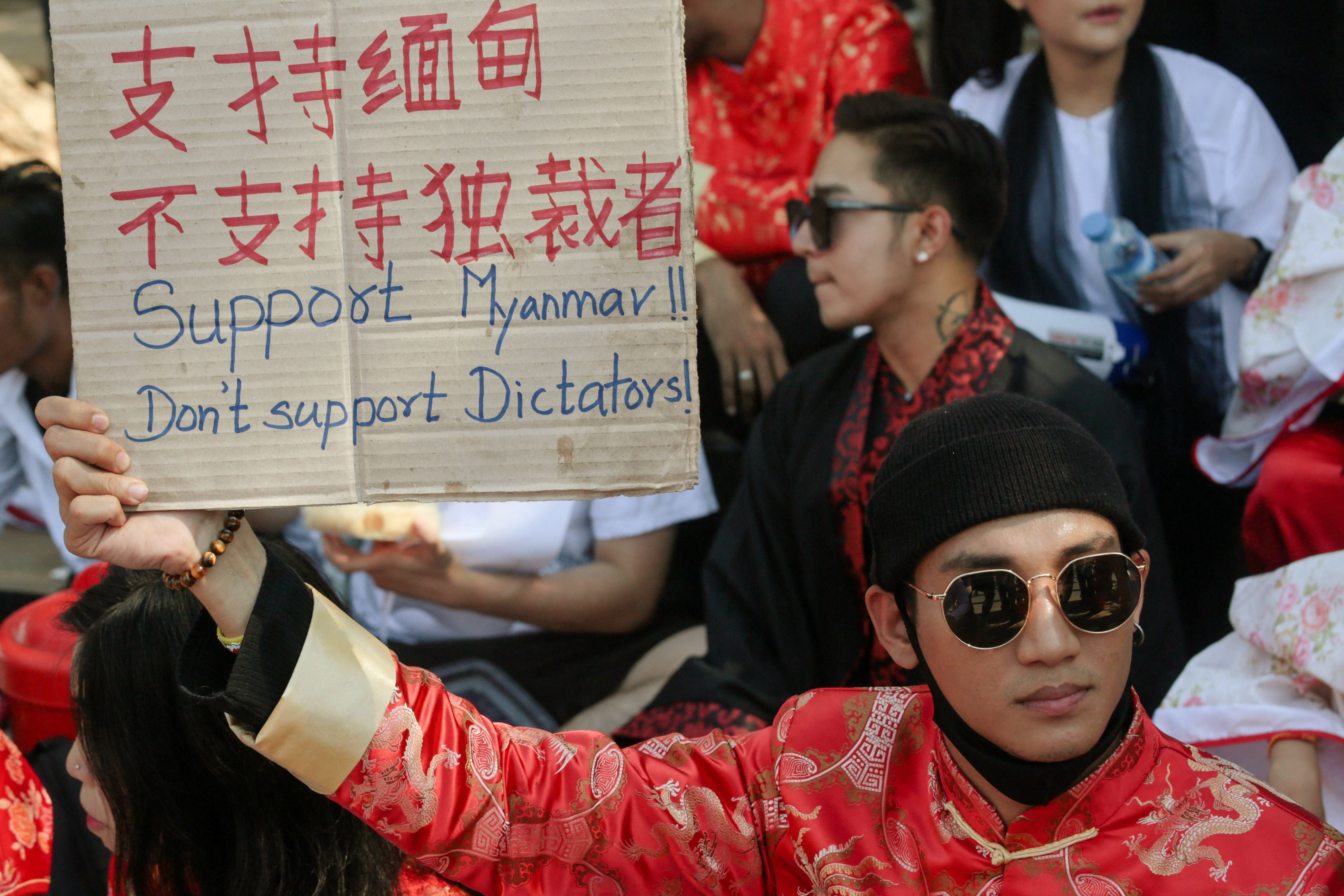 File: Paing Takhon holds a sign during a demonstration against the military coup in Yangon