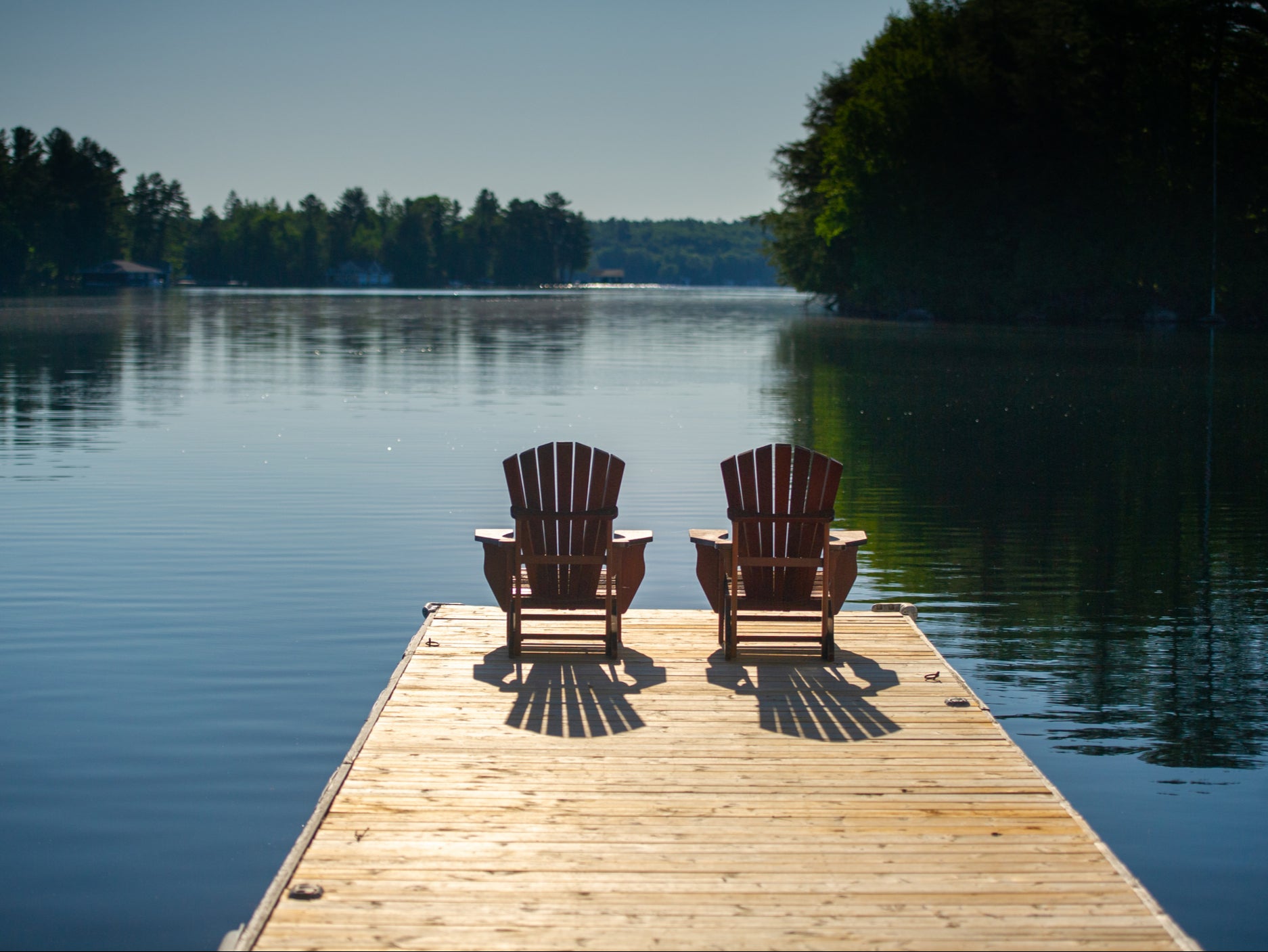 Two deck chairs sitting on a wooden pier