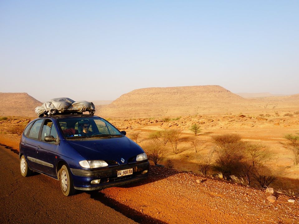 Mr Tacchetto sits behind the wheel of the little car the pair were driving when they were waylaid by jihadis with Kalashnikovs in Burkina Faso