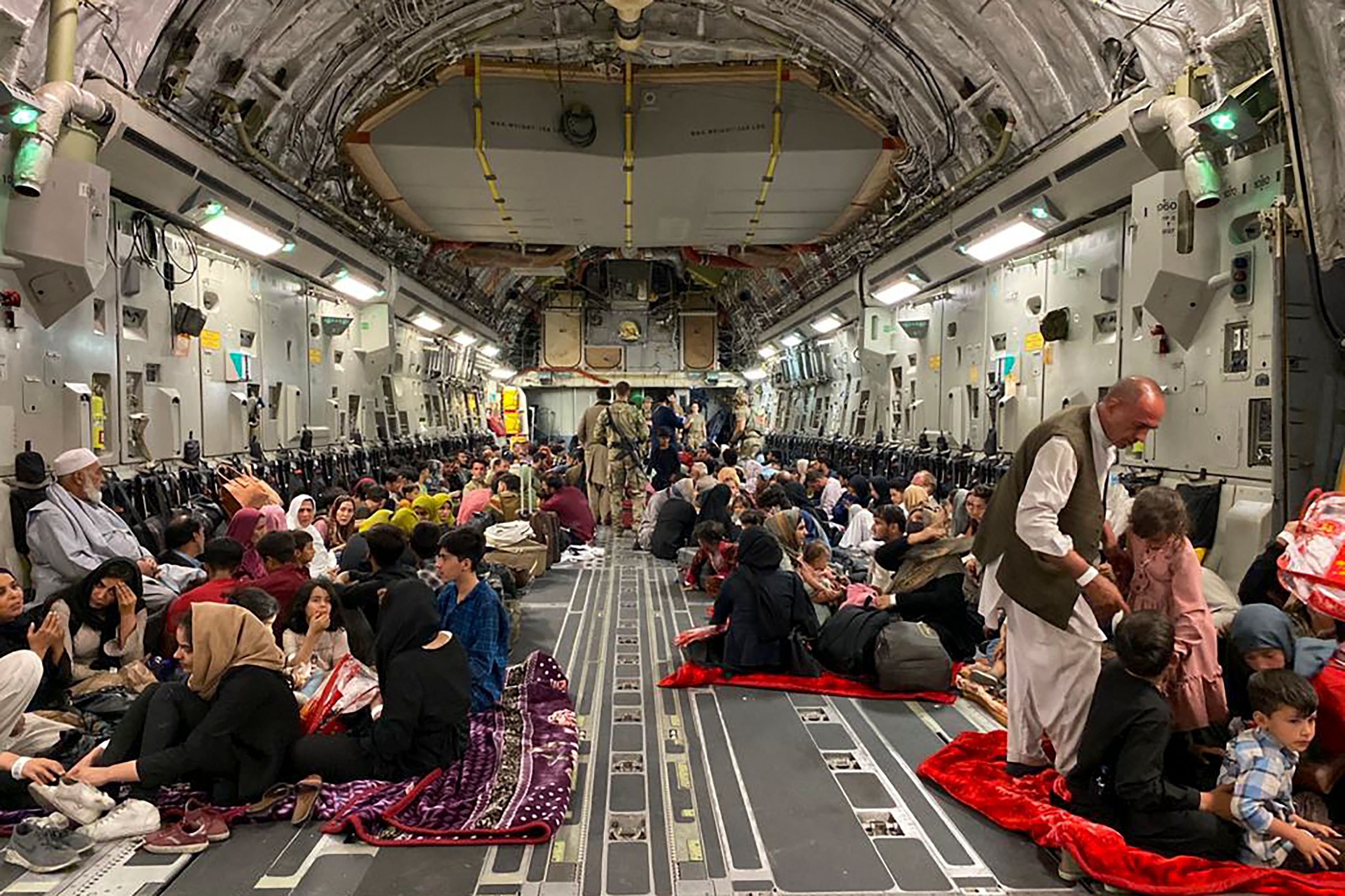 Afghan people sit inside a U S military aircraft to leave Afghanistan, at the military airport in Kabul