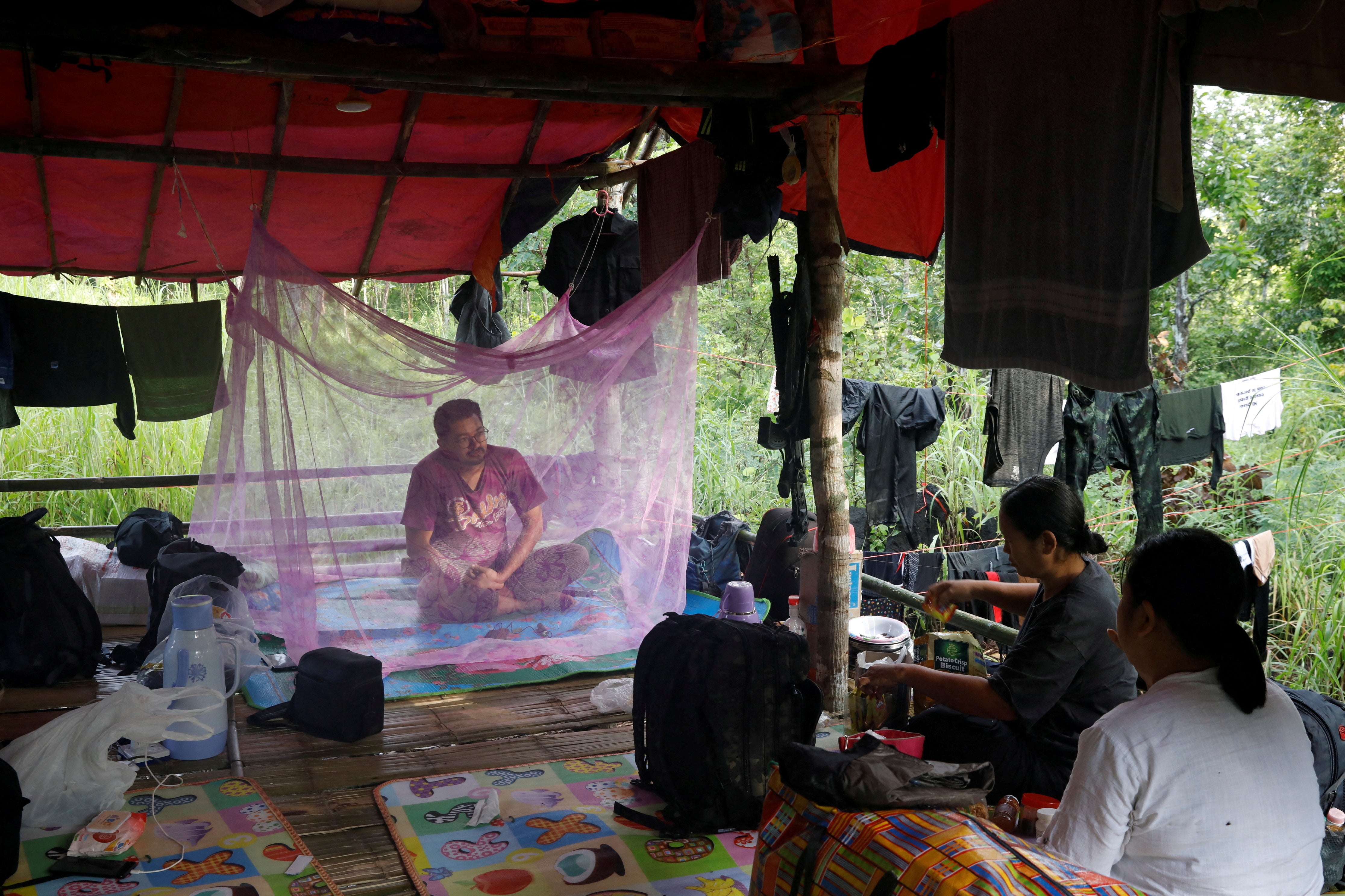 Sithu Maung, the first Muslim to be elected to parliament, in the 2020 elections, sits under a mosquito net at a training camp