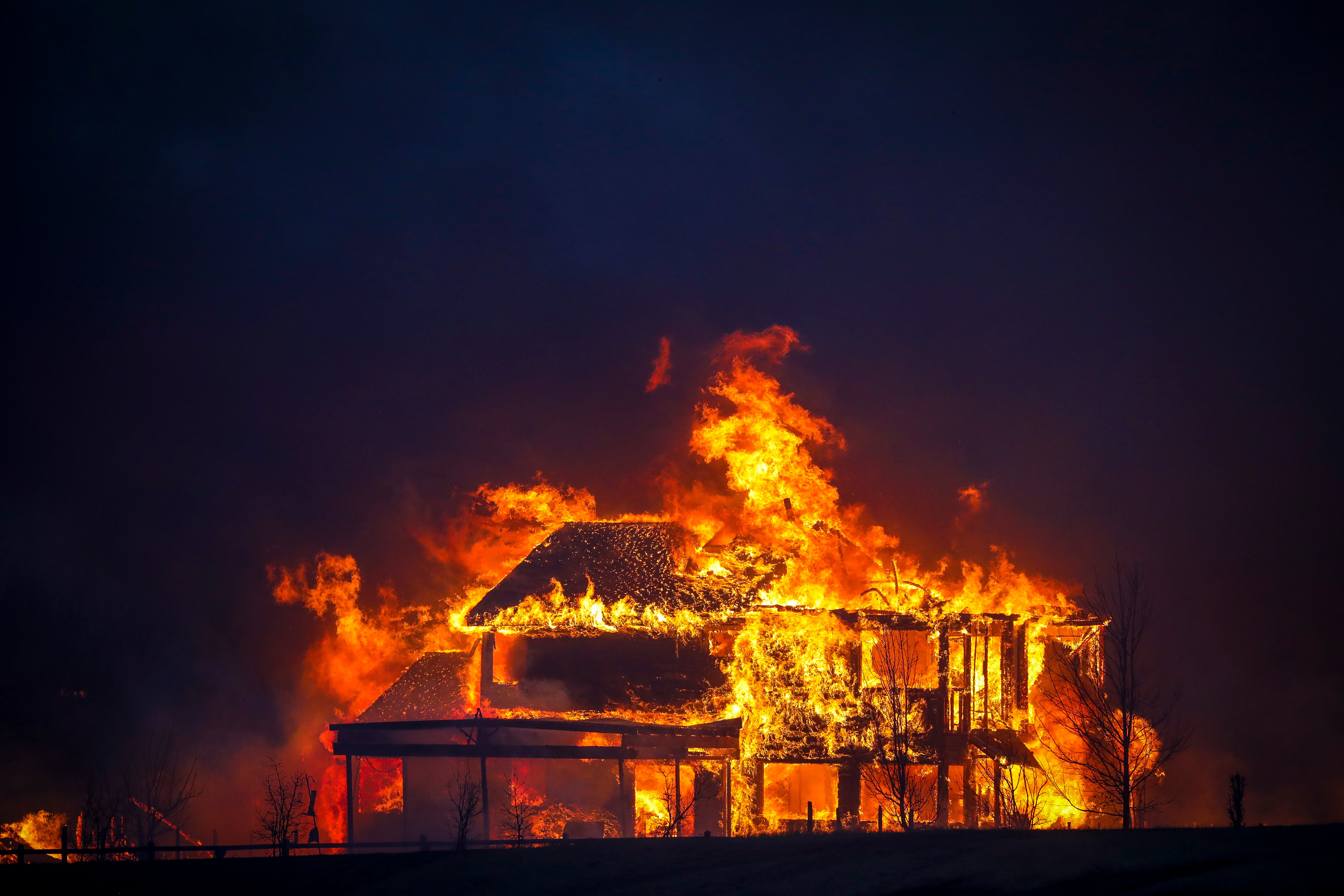 A home burns after a fast moving wildfire swept through the area in the Centennial Heights neighborhood of Louisville, Colorado on 30 December 2021