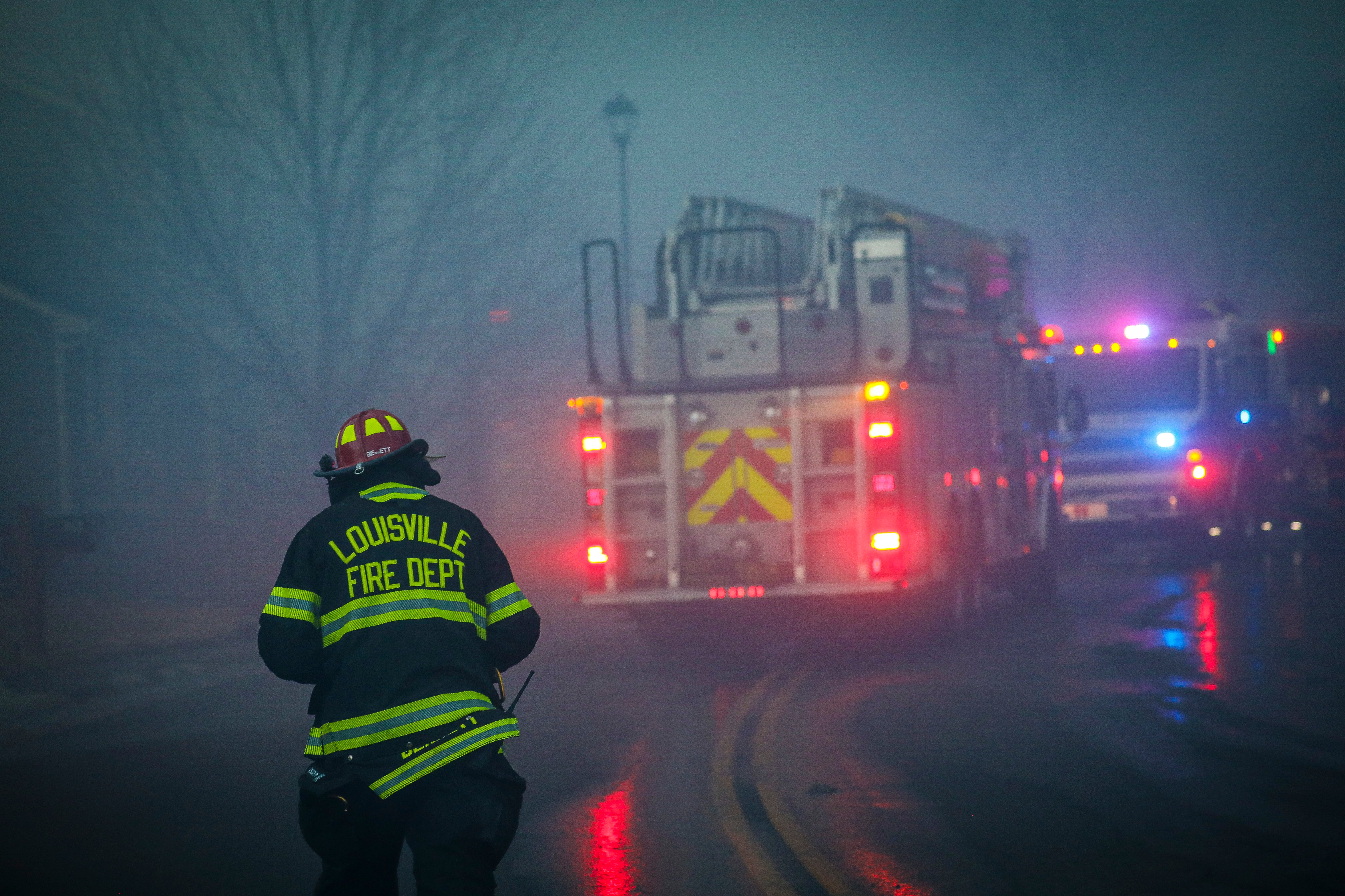 A Louisville firefighter walks through the smoke and haze after a fast moving wildfire swept through the area in the Centennial Heights neighborhood of Louisville, Colorado on 30 December 2021