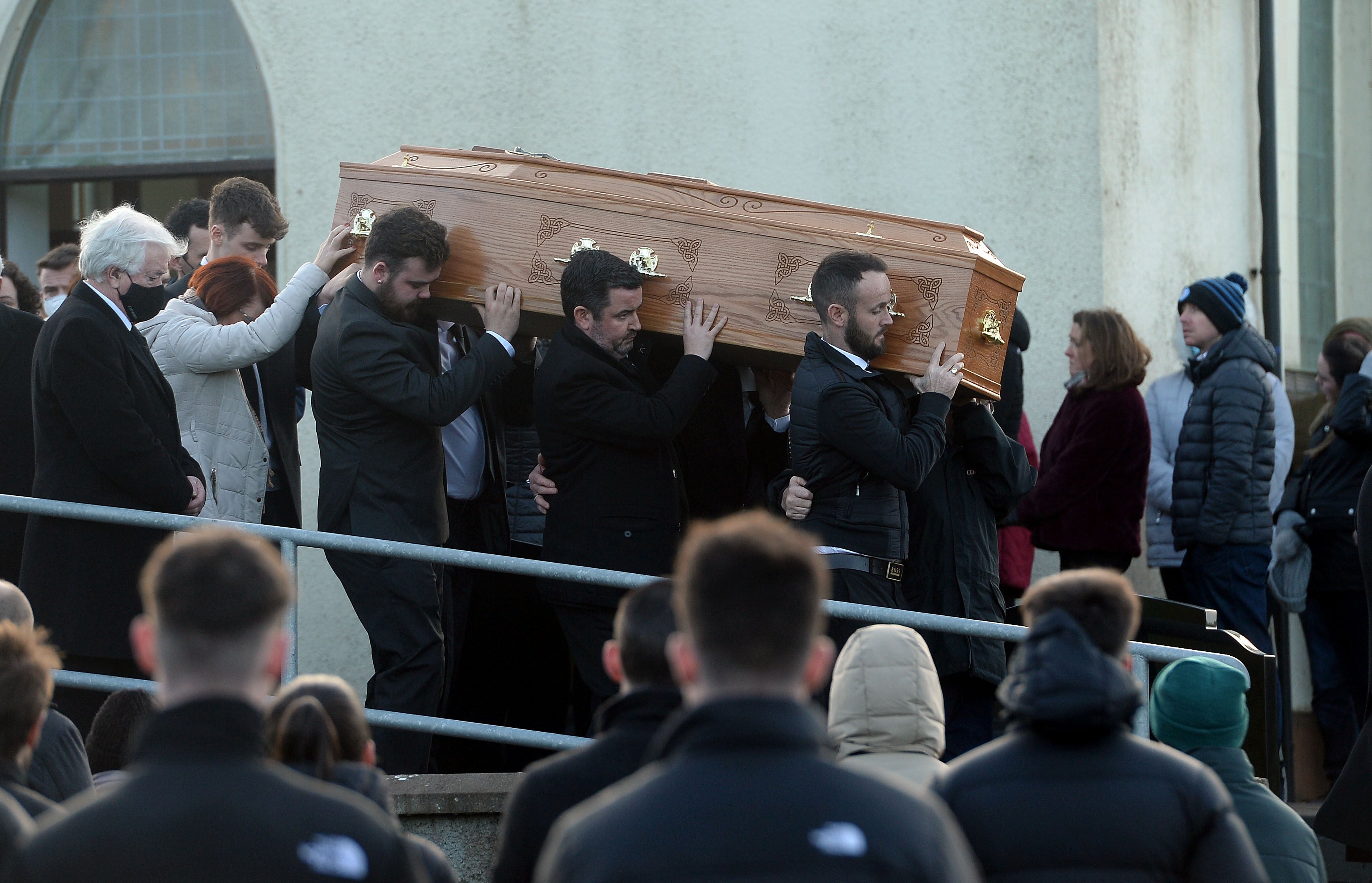 Family members hold onto the coffin of Nathan Corrigan, 20, as it is carried from St Matthew’s Church (Oliver McVeigh/PA)