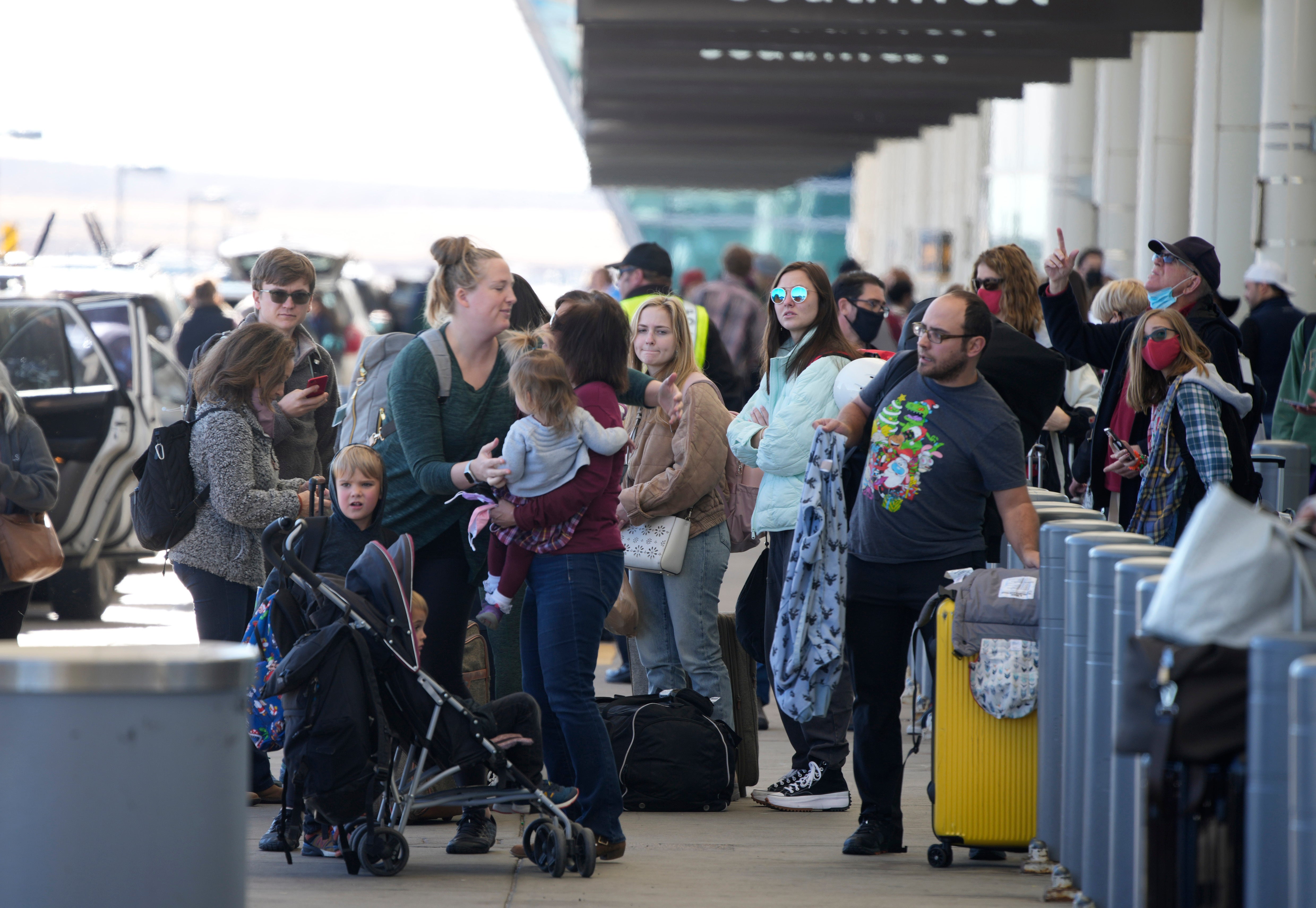 Travelers queue up at the Southwest Airlines curbside check-in area at Denver International Airport on 26 December