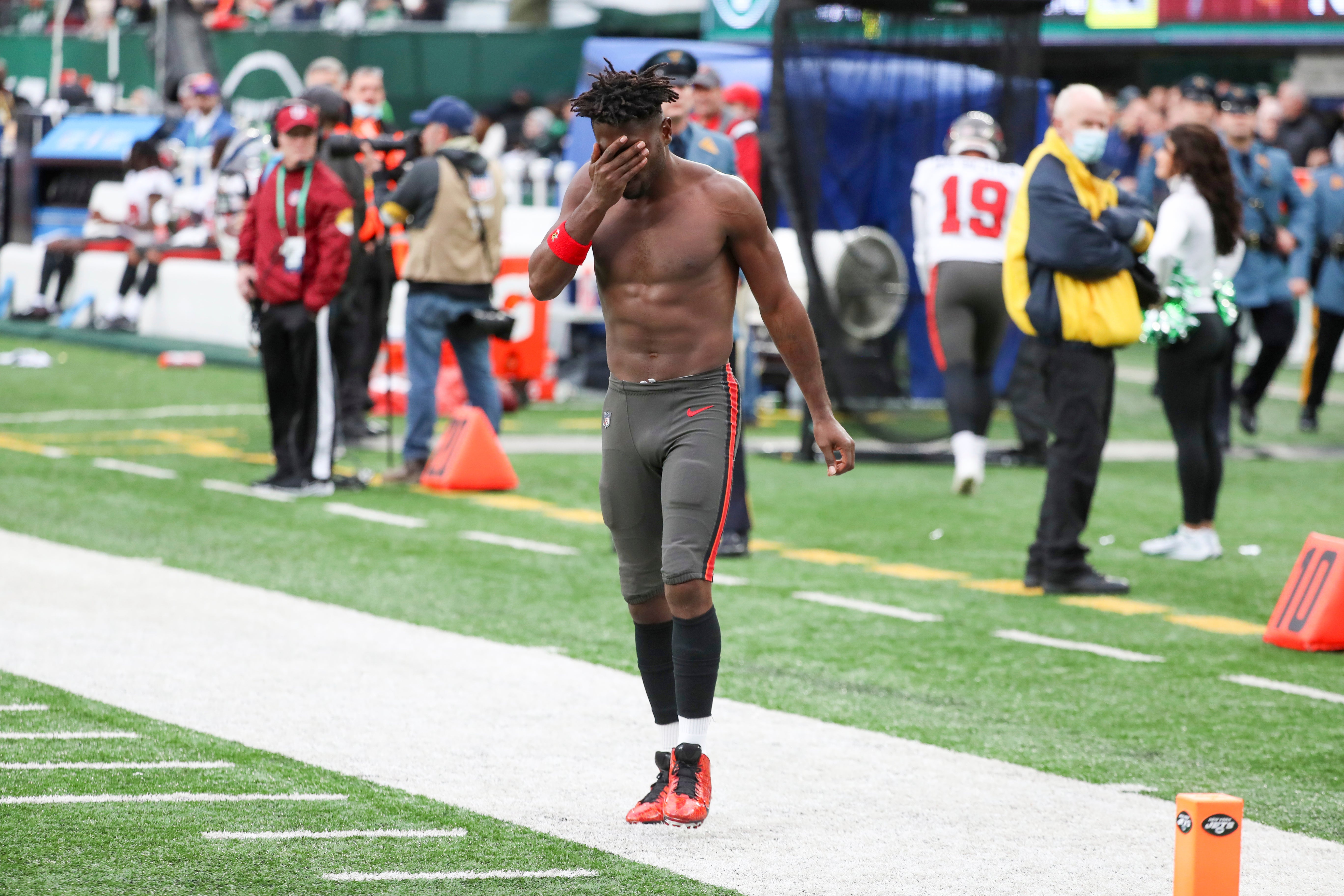 Tampa Bay Buccaneers wide receiver Antonio Brown wipes his face as he leaves the field after throwing his equipment into the stands