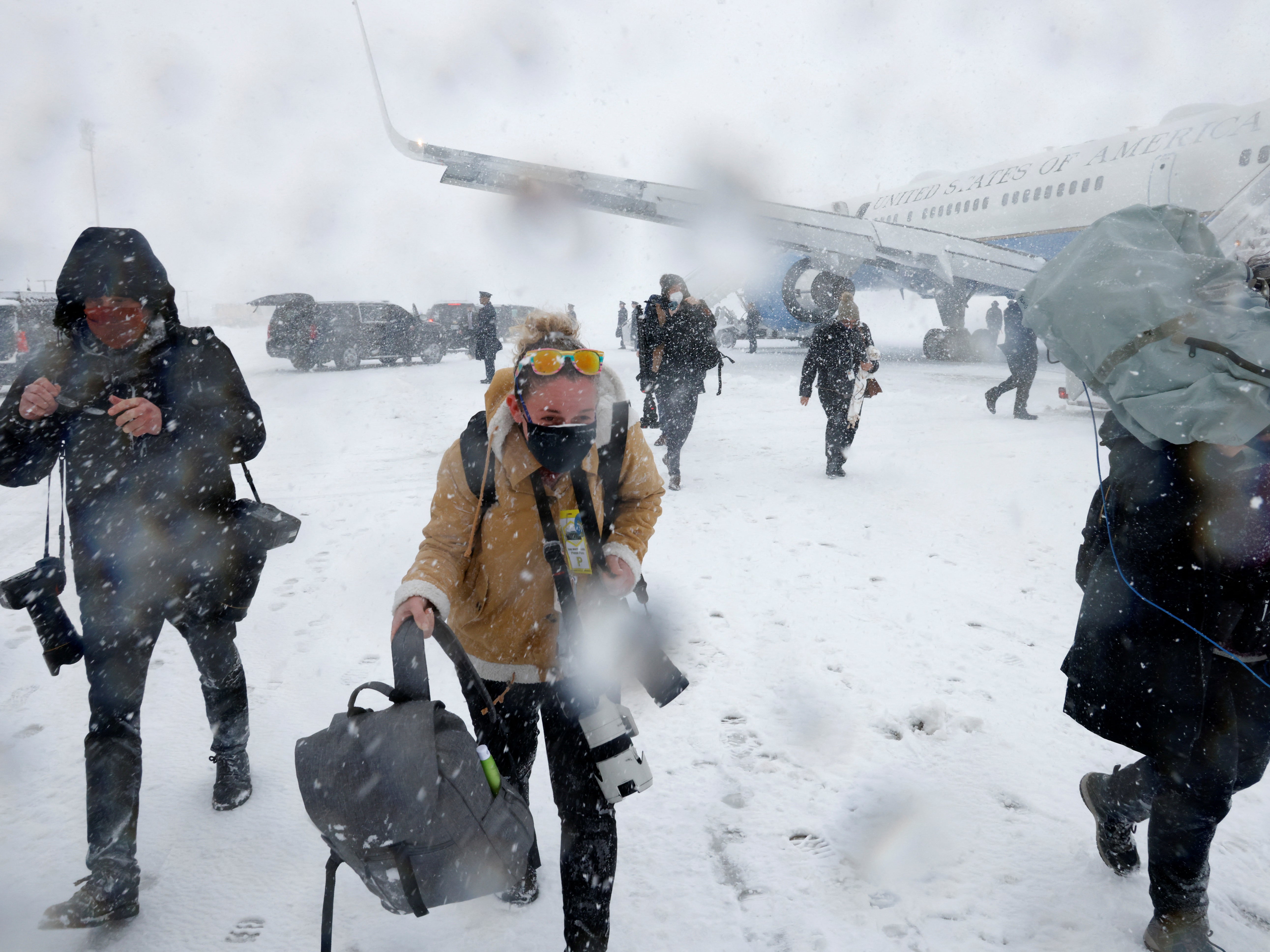 Members of the press corps walk in the snow to the motorcade, at Joint Base Andrews, Maryland, U.S. January 3, 2022