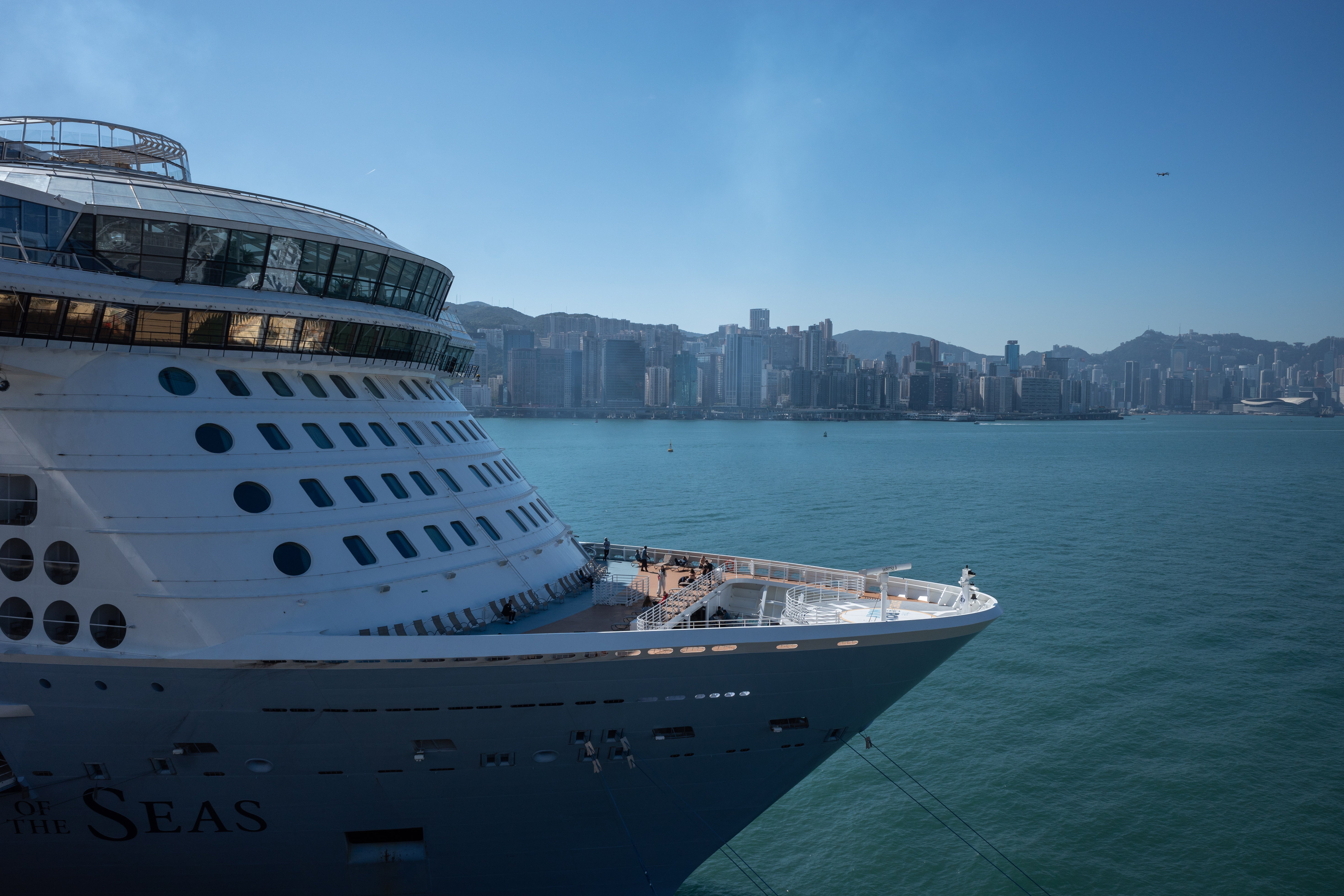 Passengers stand on the deck of the Royal Caribbean vessel ‘Spectrum of the Seas’ at Kai Tak Cruise Terminal in Hong Kong