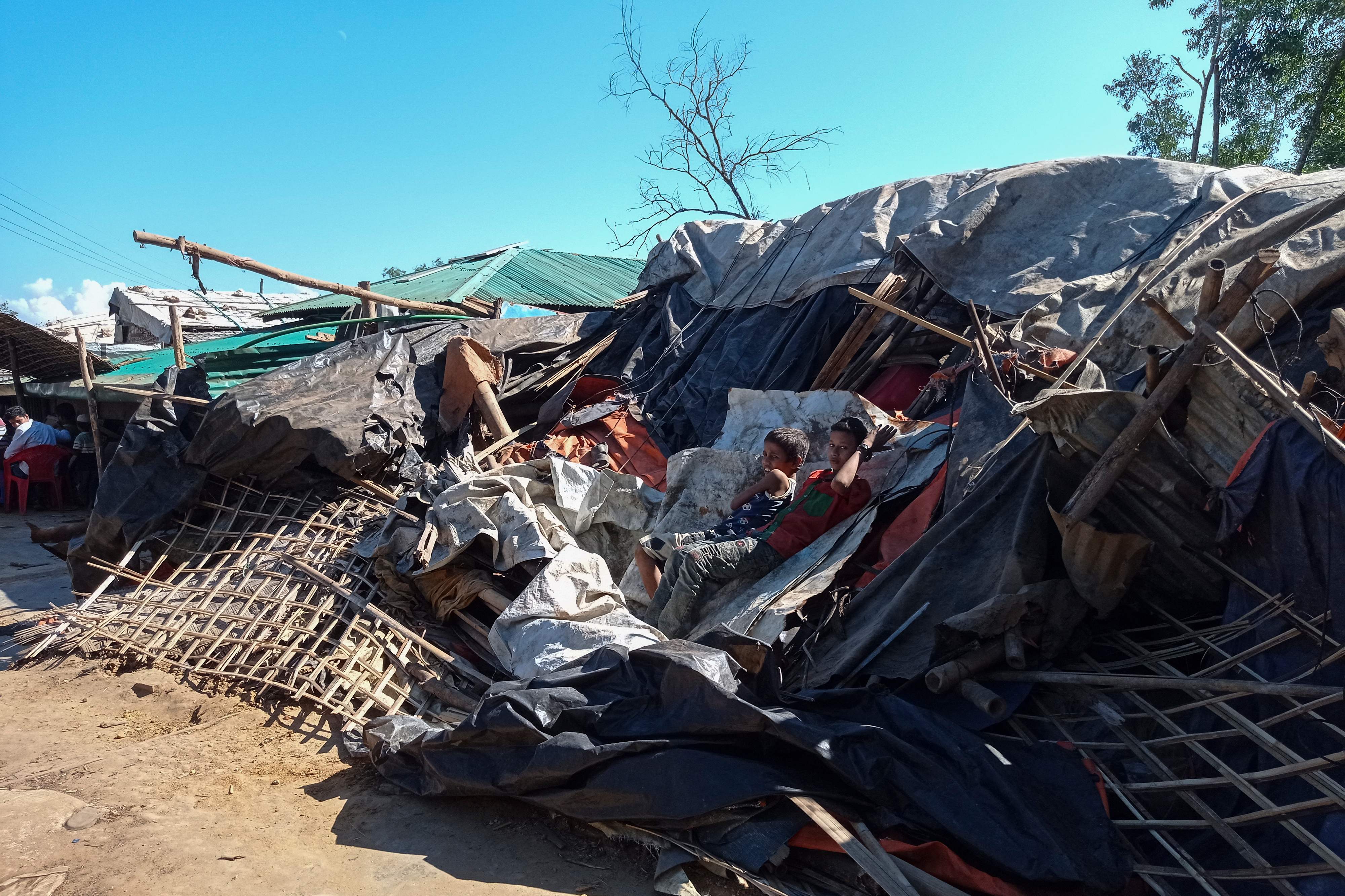 Boys lean on a razed shop at Kutupalong refugee camp