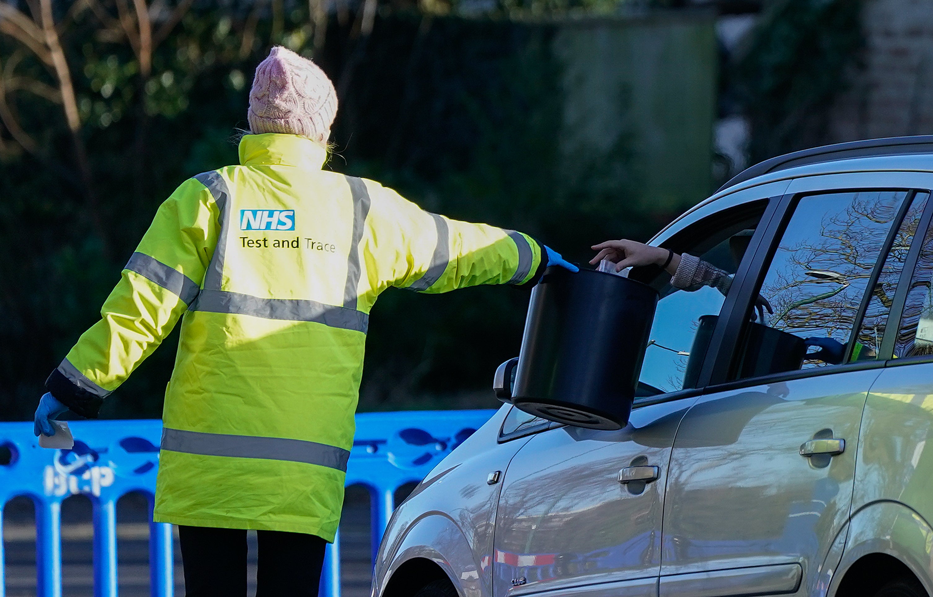 A member of NHS Test and Trace collects a sample from a member of the public at a Covid-19 testing site in Bournemouth (Andrew Matthews/PA)