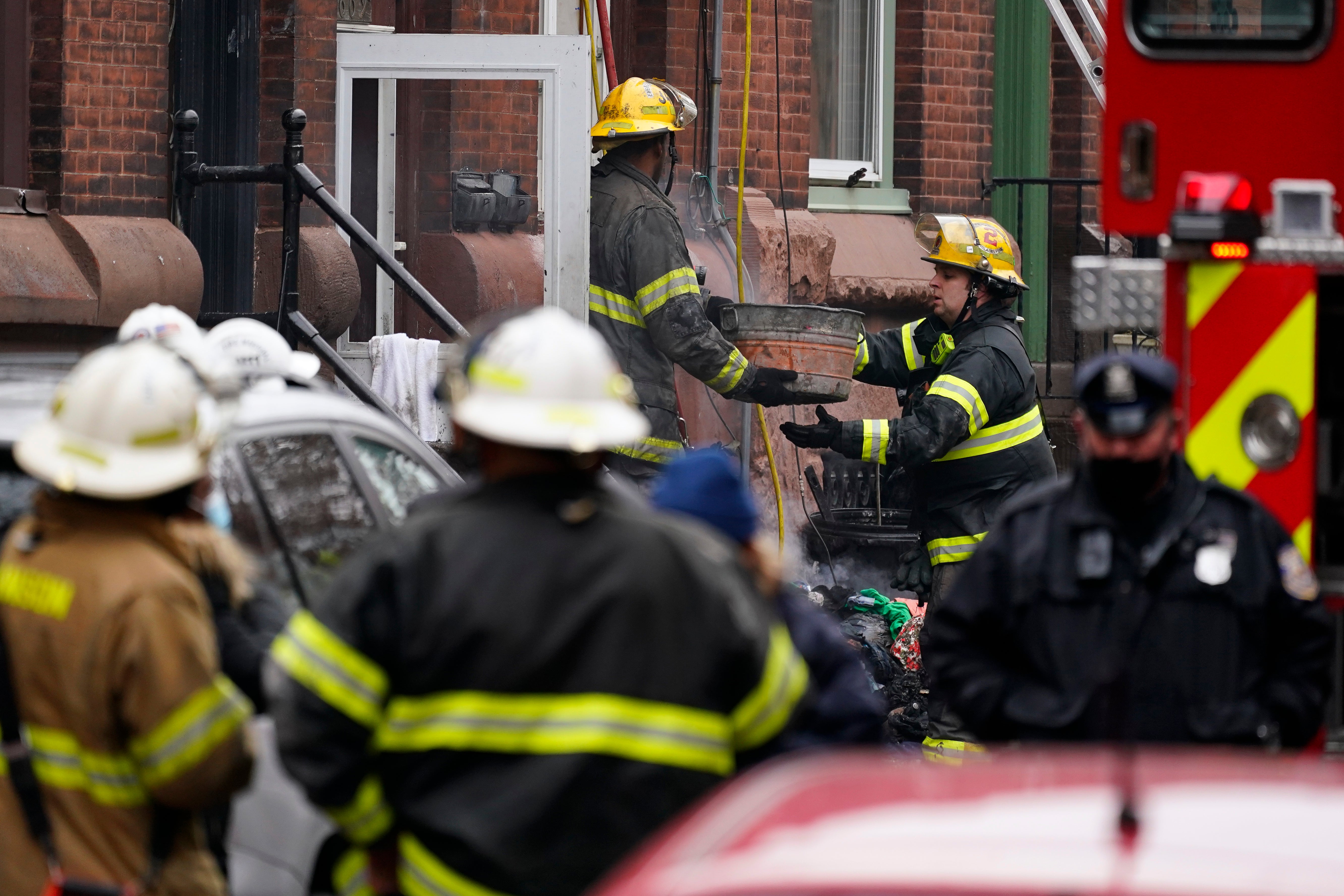 Philadelphia firefighters clear debris from the scene of a deadly row house fire, Wednesday 5 January, in the Fairmount neighborhood of Philadelphia