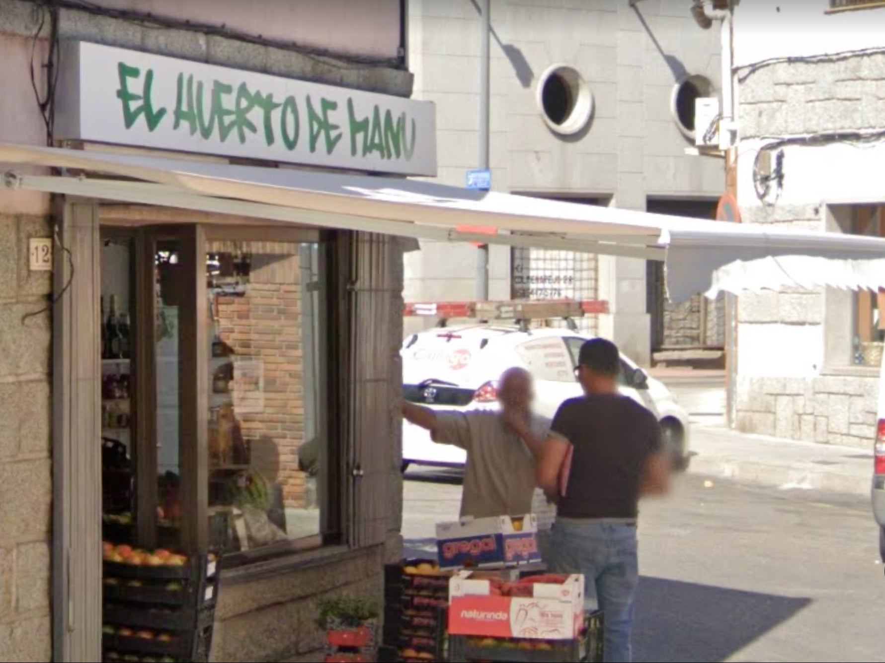 Gioacchino Gammino (L) speaking with a man outside a fruit shop in Spain