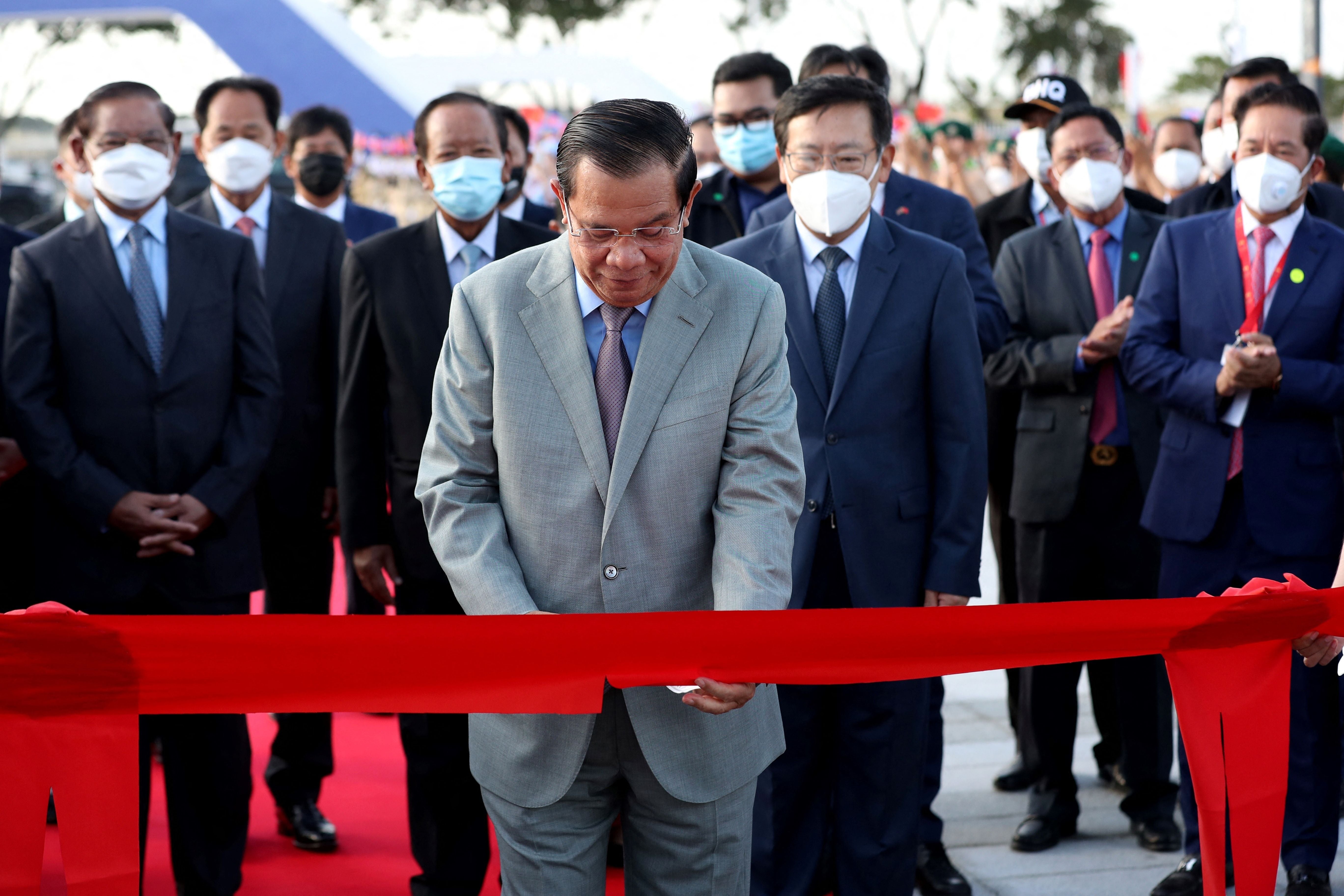 Hun Sen cuts a ribbon to mark the opening of the Morodok Techo National Stadium, funded by China, in Phnom Penh, December 2021