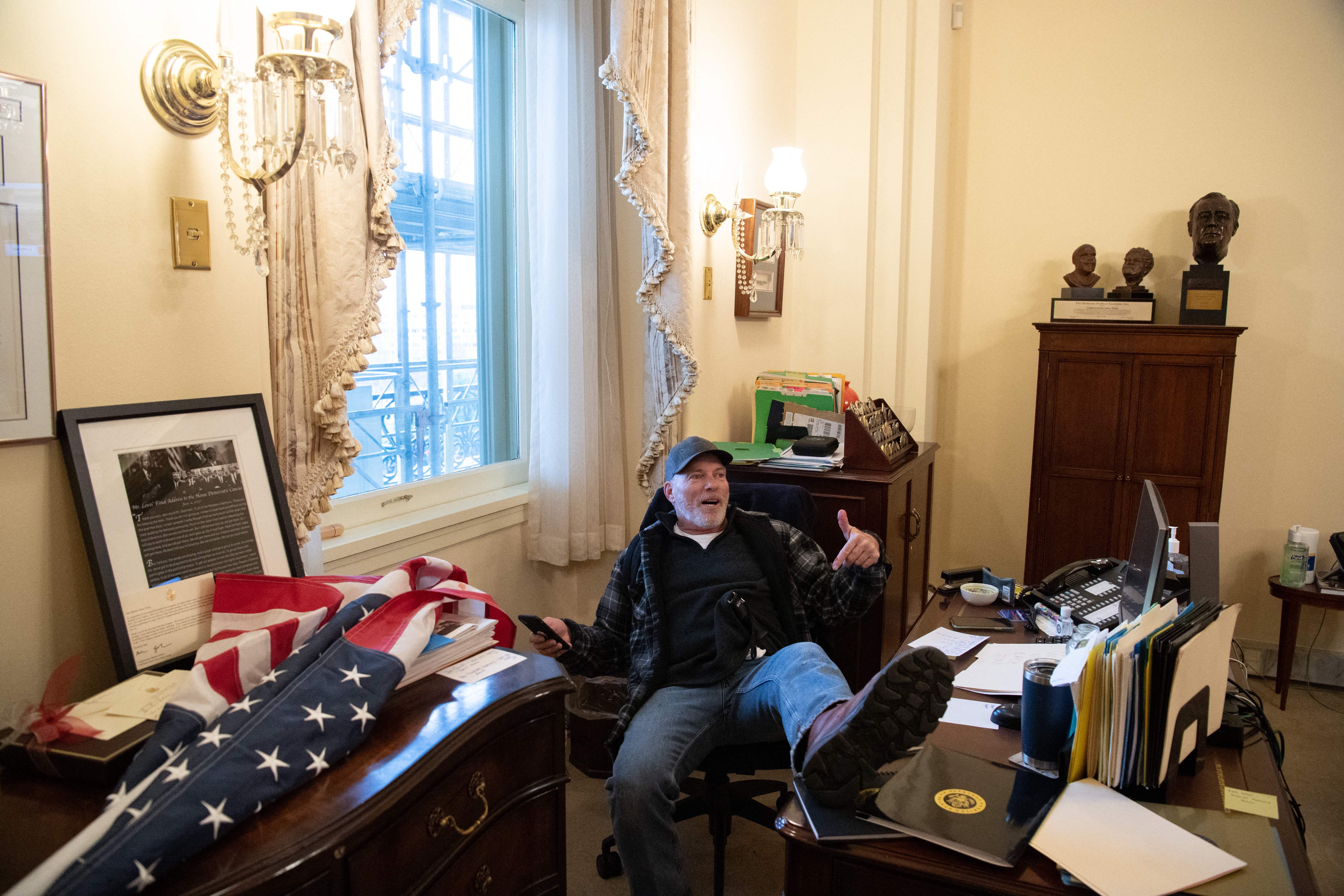 Richard Barnett pictured on January 6 in the office of US Speaker of the House Nancy Pelosi (Photo by SAUL LOEB/AFP via Getty Images)