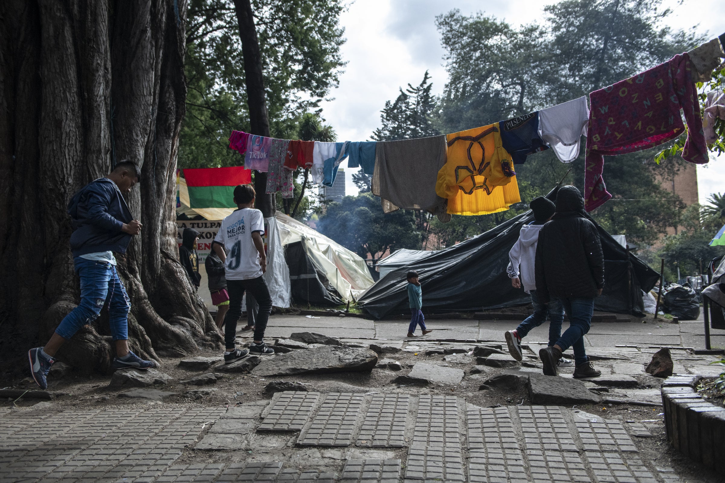 Young people walk through the camp in Bogota’s national park